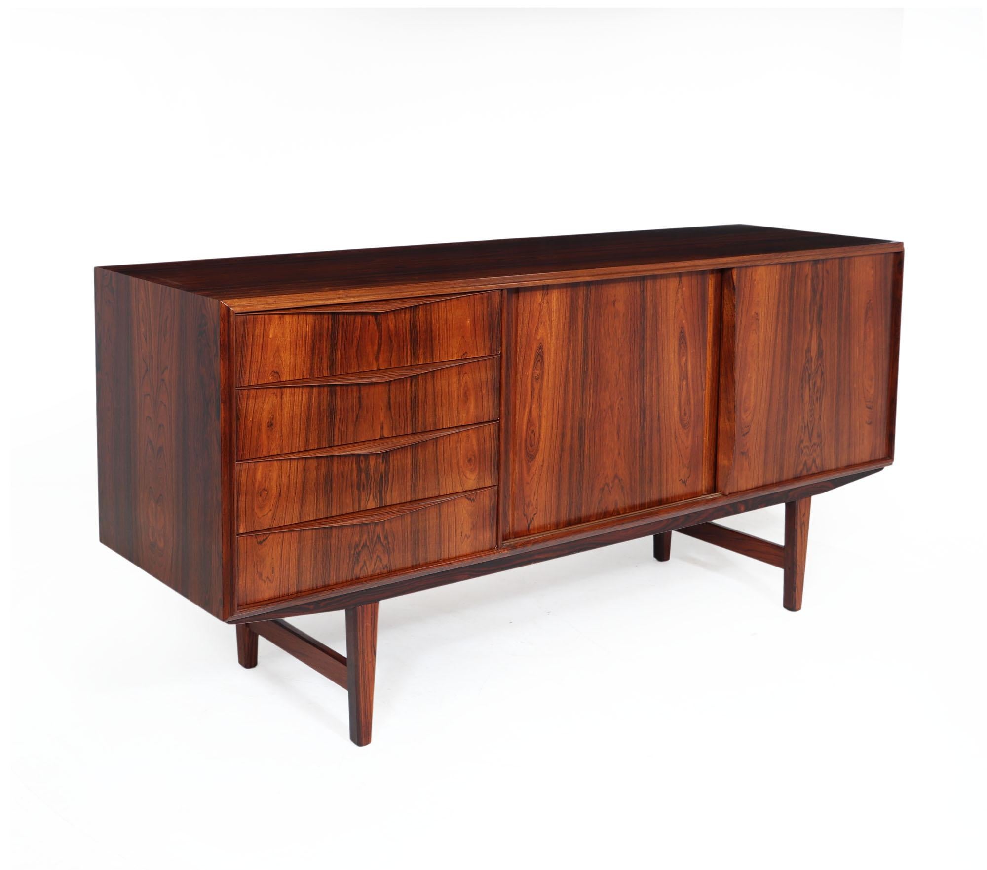 Midcentury sideboard
A midcentury sideboard produced in the 1960s in Denmark, it has four drawers to the left with sculpted handles and two sliding doors on the right with adjustable height shelf behind, it stands on an under frame and raised by