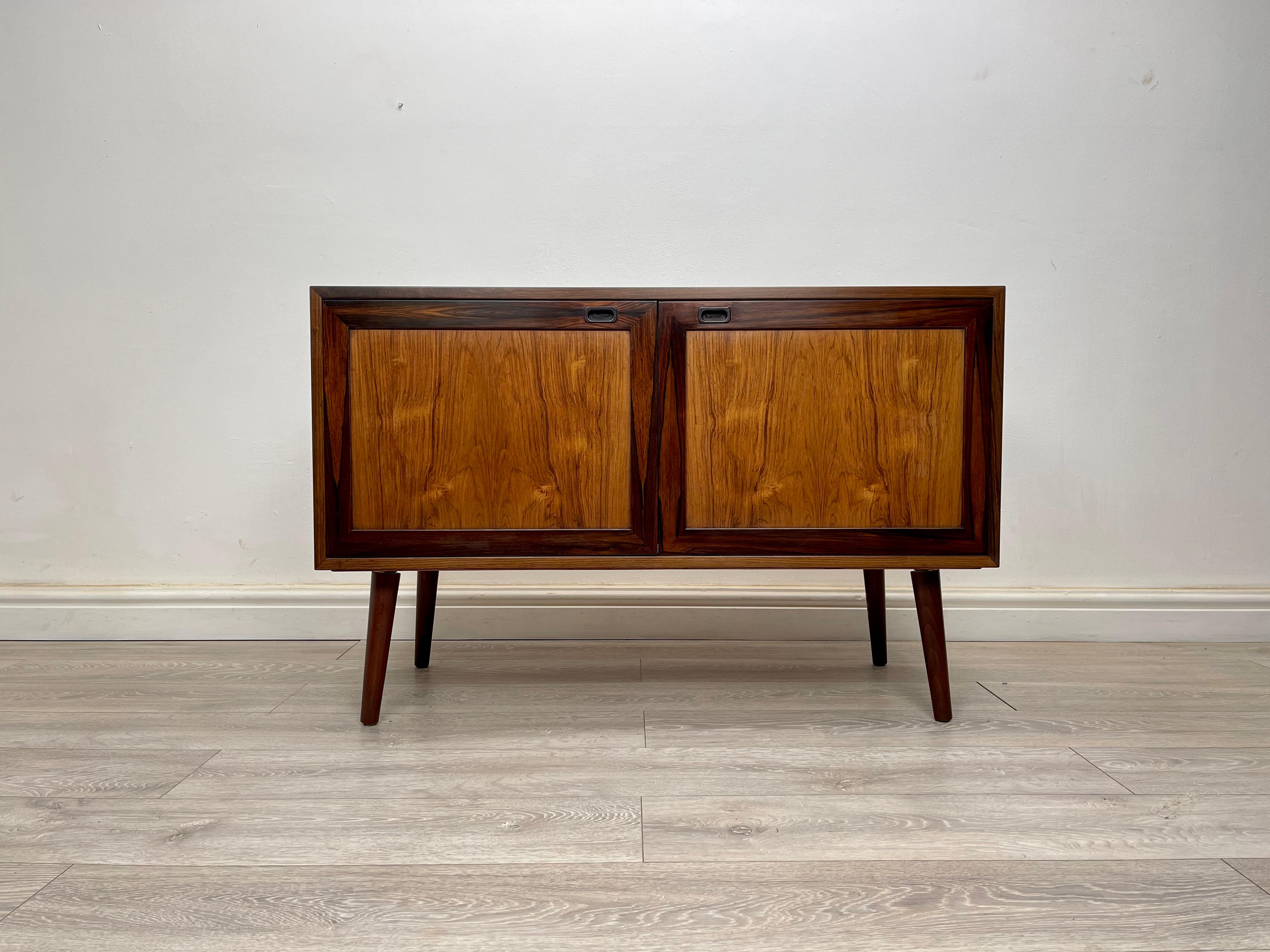 SIDEBOARD 
Midcentury Danish rosewood sideboard / cabinets circa 1970s. The cabinet has stunning grain throughout, stands on round dansette legs. There’s two single cupboards with adjustable shelves. 

Dimension 
Height- 72 cm 
Width- 110 cm