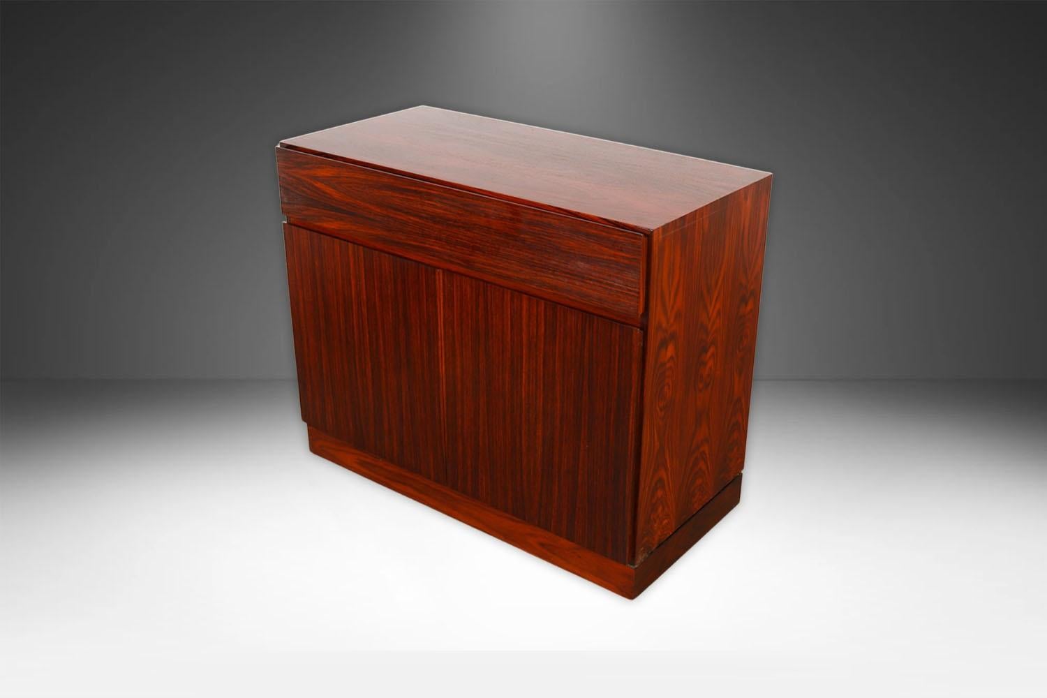 Una bellissima credenza danese moderna a due ante in legno di palissandro degli anni '60, disegnata da Arne Wahl Iversen e prodotta in Danimarca da Vinde Mobelfabrik. Questo pezzo è un'opera di artigianato eccezionale con splendidi interni; la