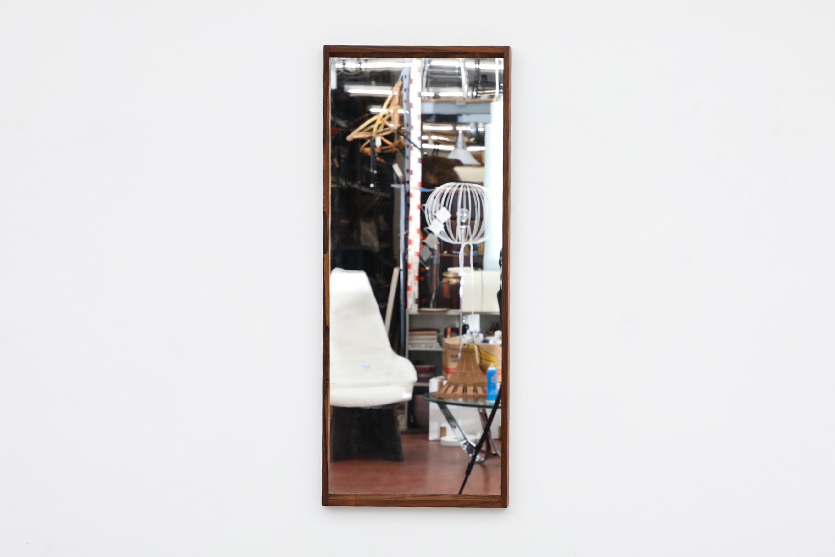 Midcentury Danish mirror with a rectangle rosewood frame with beautiful peg fastening detail. It's in original condition with visible patina consistent with its age and use.