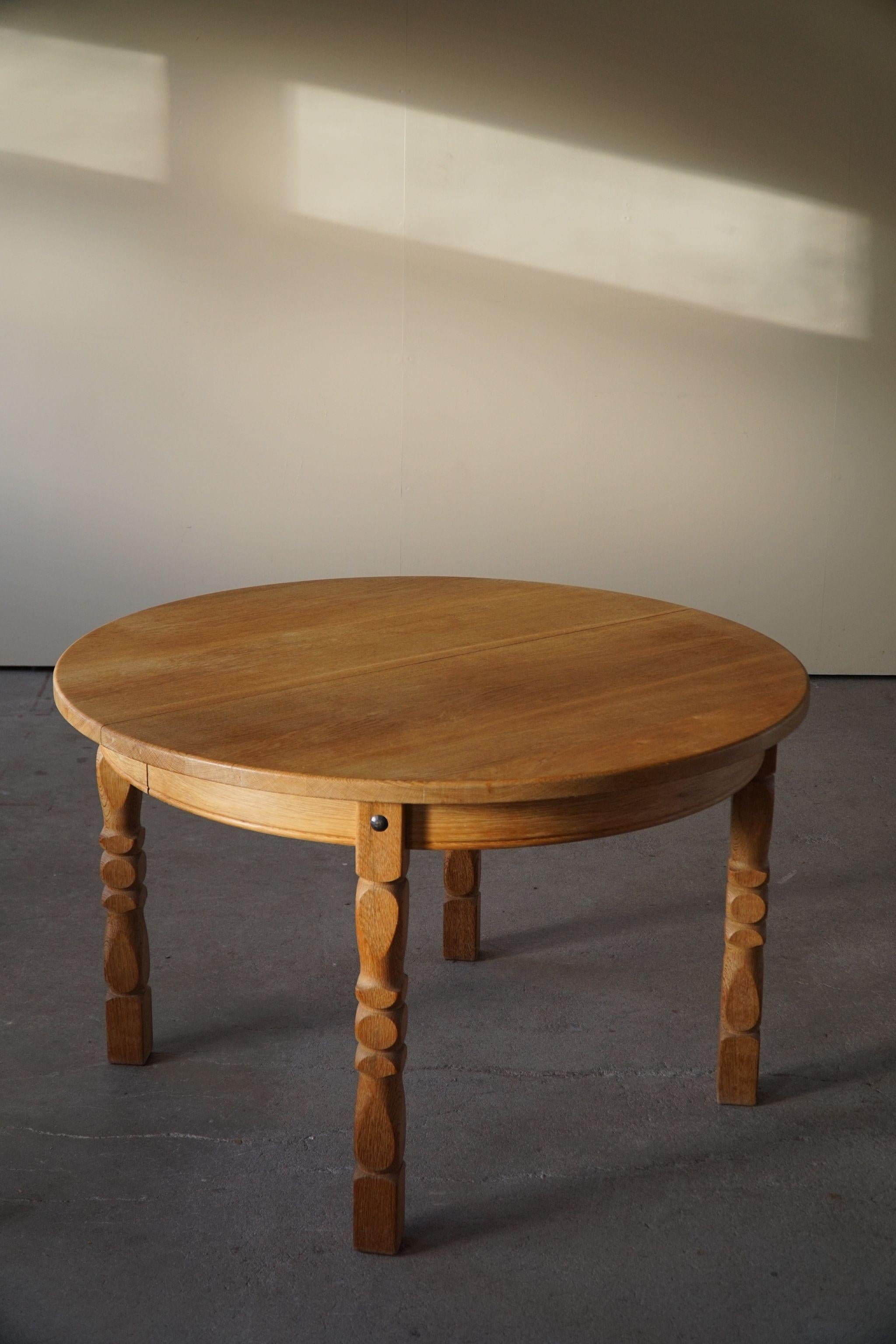 Classic round dining table in solid oak with two extensions, made in 1960s by a Danish Cabinetmaker. Such a sculptural figure for the modern interior.

Curved legs and great craftmanship in this brutalist table. 
Light signs of wear on the