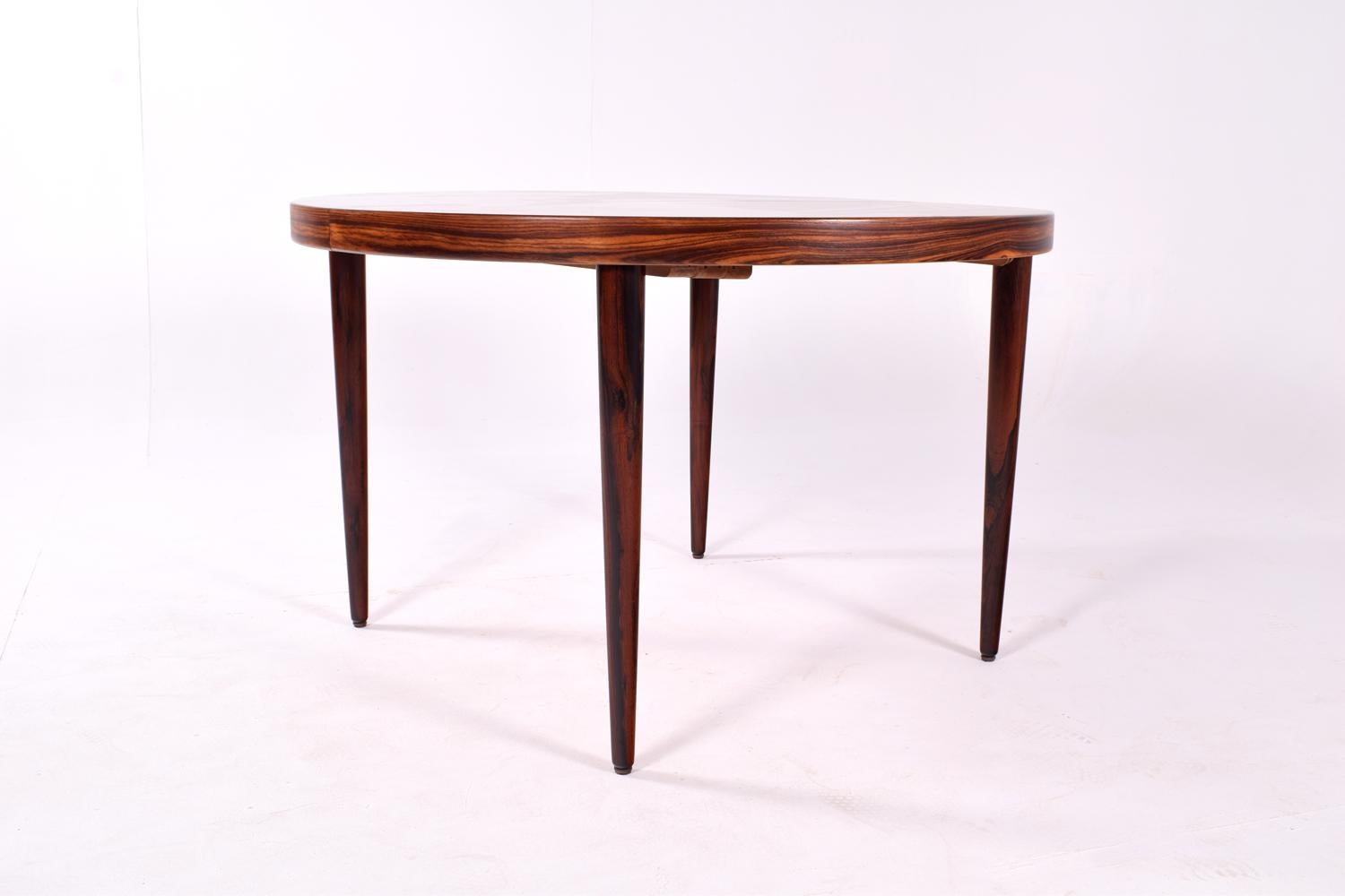 Round dining table designed by Kai Kristiansen in rosewood. Simple and beautiful tapered cigar legs, with an additional extension leaf, 55cm, for the guests.
Amazing veneer on top, around and on the legs, exhibiting all the vivid nuances of