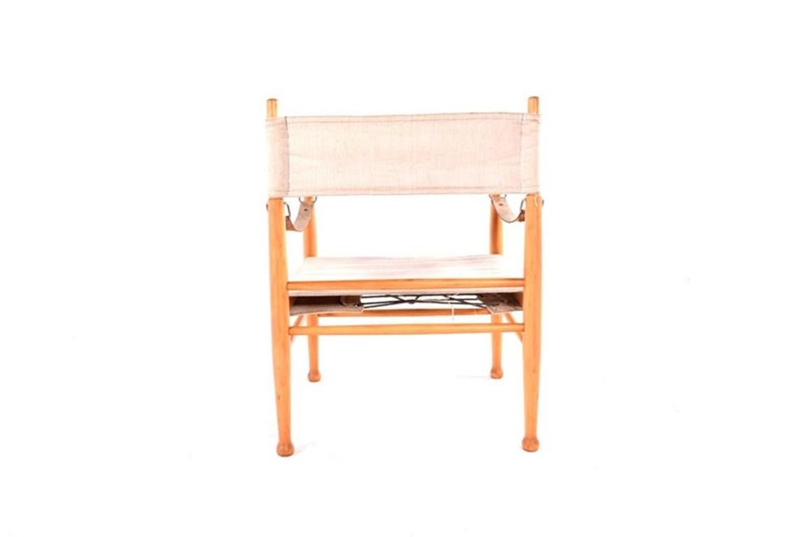 Esta silla safari vintage de los años 60, fabricada por el danés Farstrup Stole, es un impresionante ejemplo de artesanía escandinava. El armazón de la silla es de madera maciza, con líneas limpias y una estética minimalista típica del diseño de