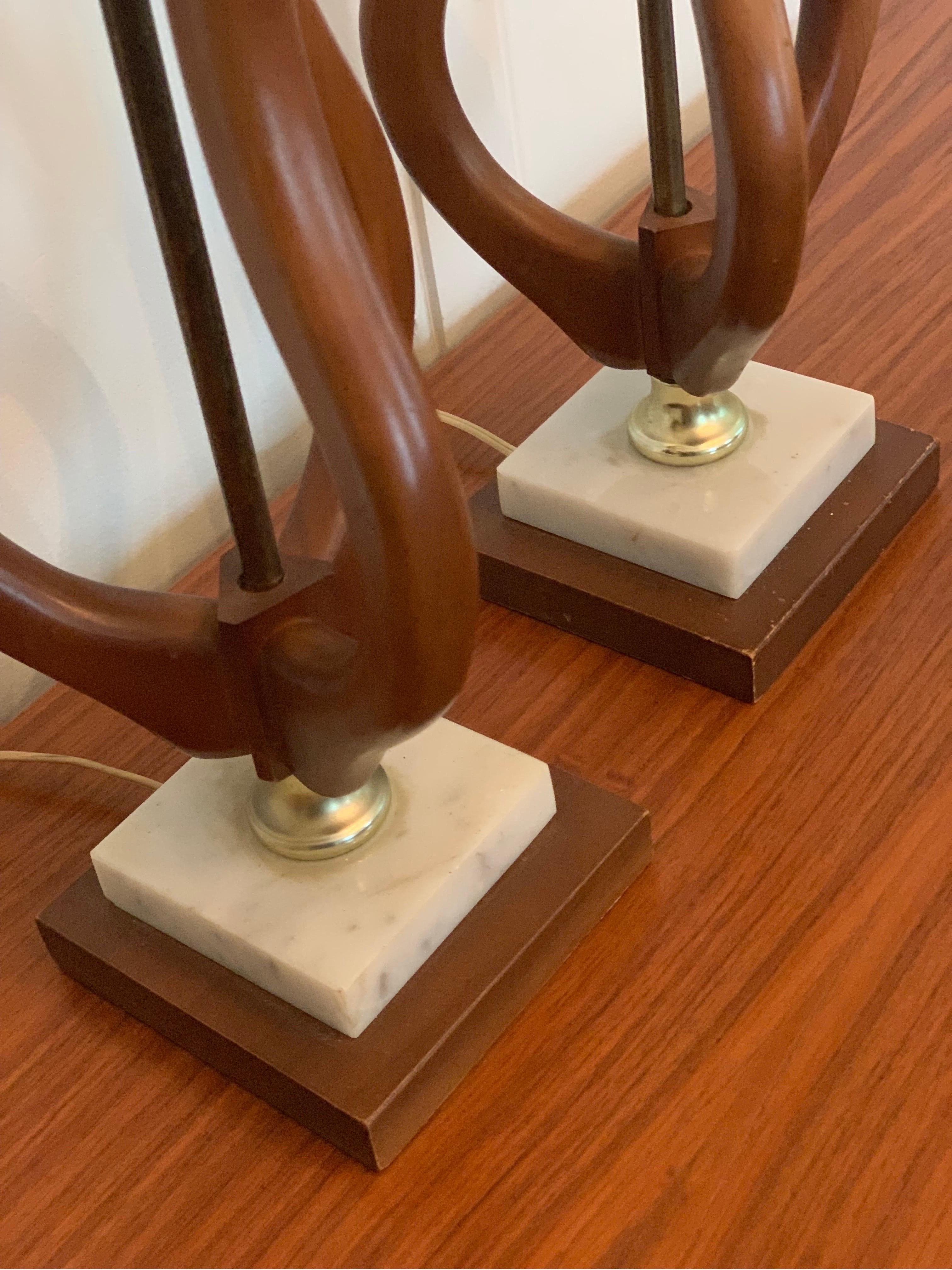 Vintage pair of sculptural teak and brass lamps with a marble and teak base. Both are in excellent condition and in good working order. 6