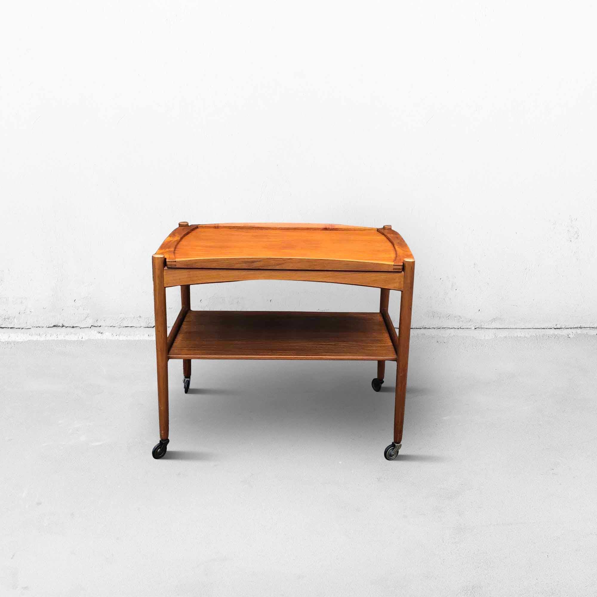 Danish serving trolley or table in teak designed by Poul Hundevad from the 1960s. This bar cart is in two levels, the top level of which is a removable tray. The wheels are in original condition and still run smoothly. This bar trolley is very
