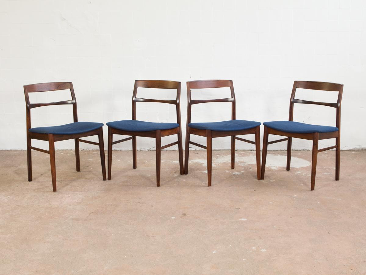 Mid-century set of 4 chairs designed by Henning Kjaernulf and manufactured by Vejle Stole- og Møbelfabrik (V S&M) in Denmark in the 1960s. The solid rosewood has beautiful expressive drawings. The blue fabric is original and has some less visible