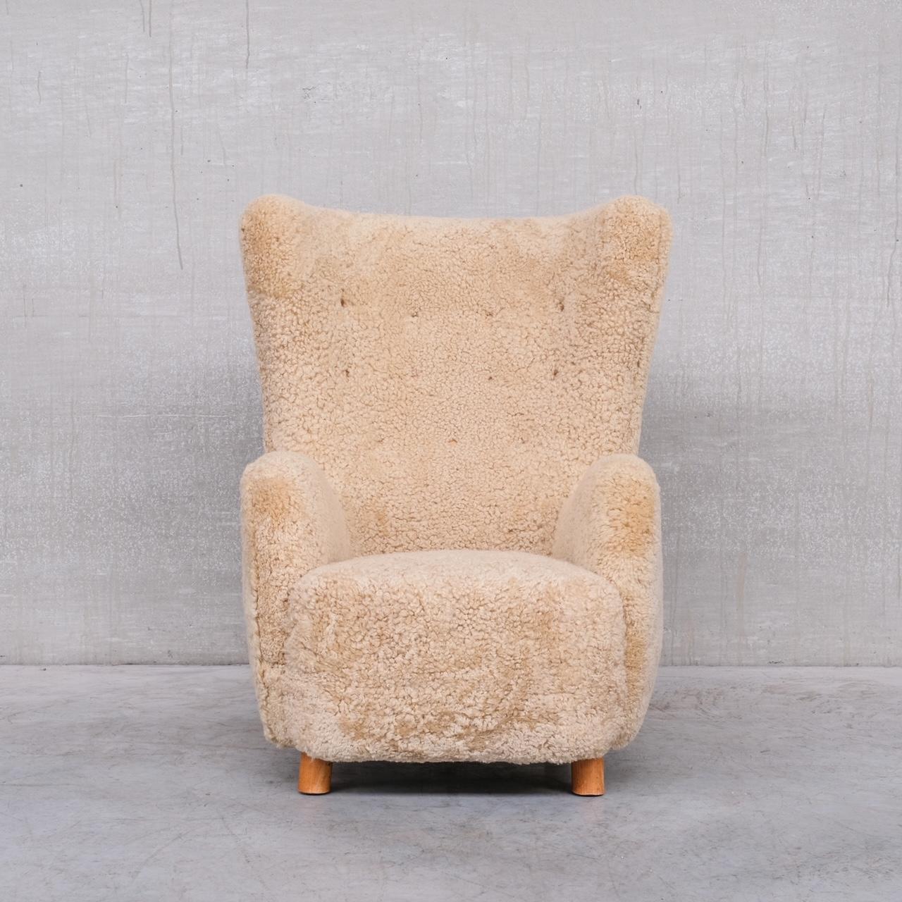 A tall generous armchair, in caramel sheepskin shearling. 

Denmark, c1960s. 

Attributed to top Danish modernist designer Mogens Lassen. 

Particularly attractive stance to the arms and the curved top. 

High quality re-upholstery, the