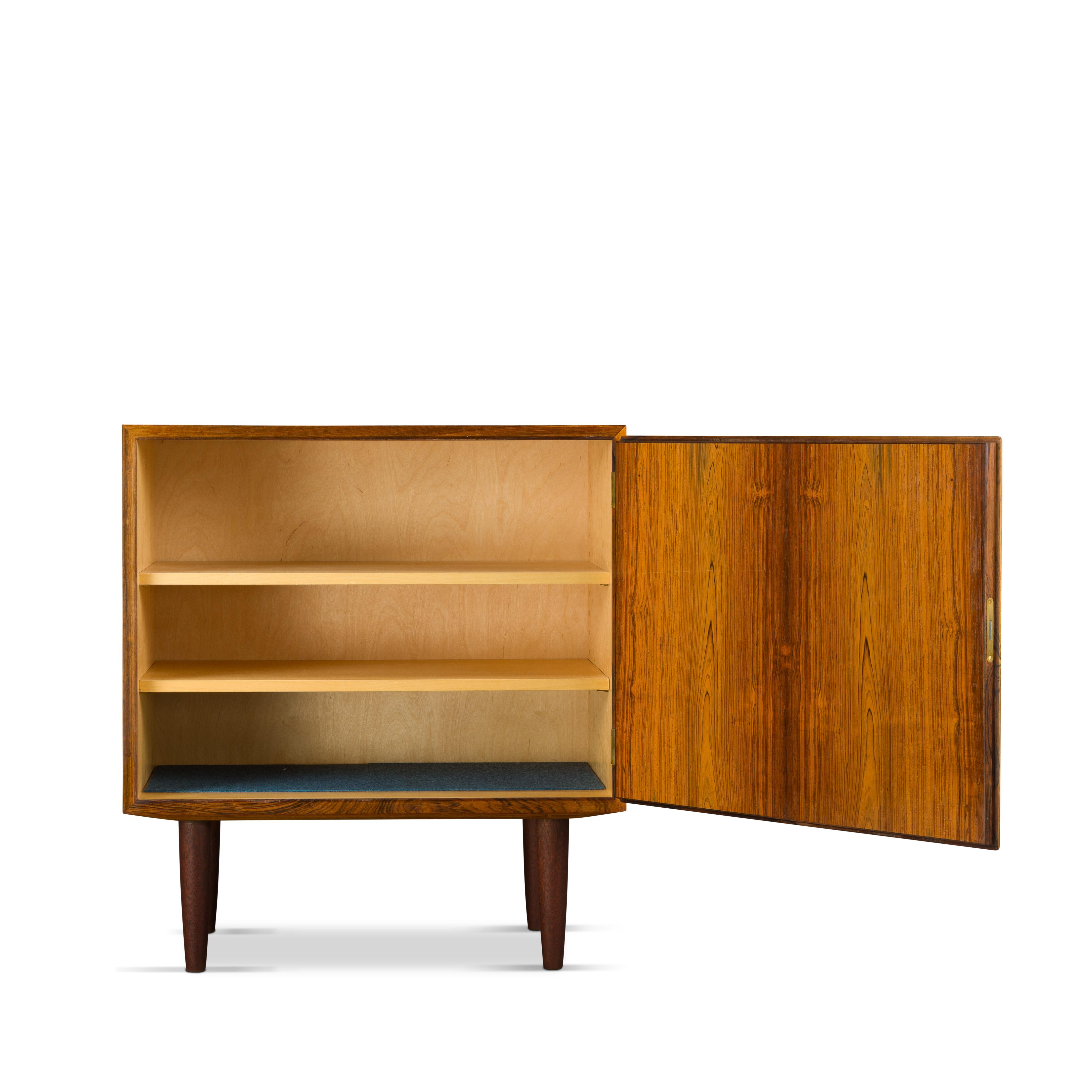 Designed by Carlo Jensen and made by Hundevad & Co. This rosewood small one door side board is truly beautiful. Two adjustable shelves in this credenza.