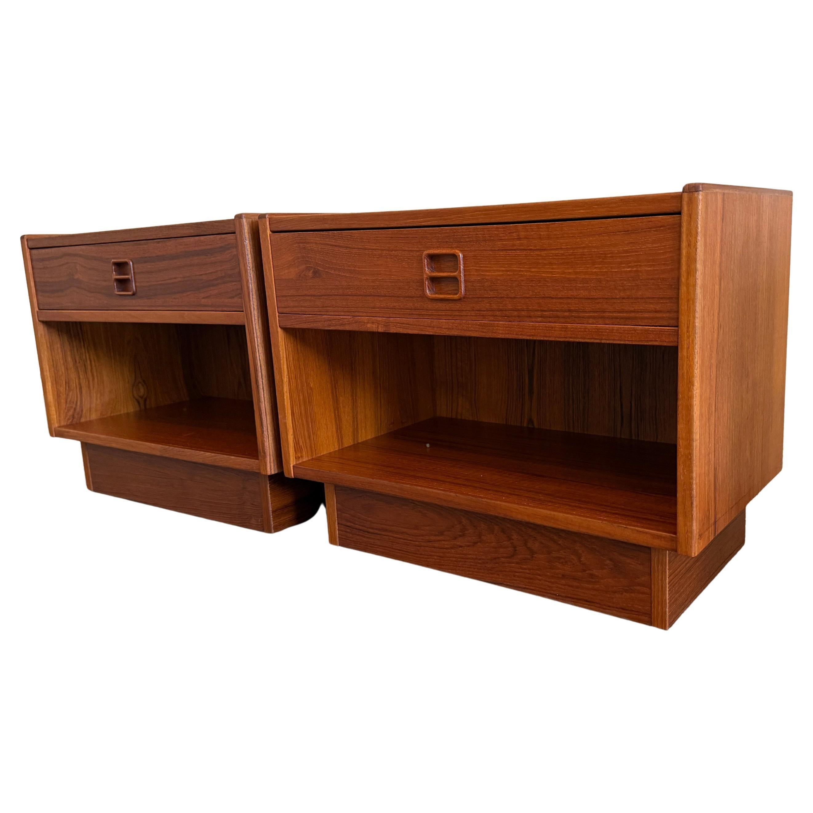 Paire de petites tables de nuit danoises en teck du milieu du siècle par Erik Brouer. Fabriqué au Danemark. Chaque table de nuit comporte un seul tiroir avec poignée sculptée et un casier en dessous. Posé sur un socle en teck. Vendu en tant que