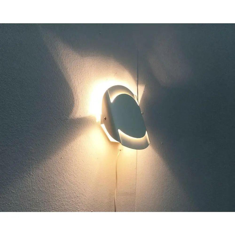 Semplici lampade da parete del produttore danese Lyfa.

La semplice forma di base viene alleggerita dalla forma arrotondata. La luce passa attraverso le fessure nell'area superiore e inferiore e mette in scena la forma dell'apertura. L'elemento