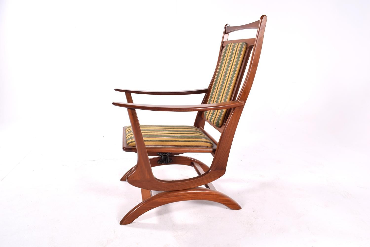 The spring rocking chair has a high back and deep design for comfort and support. It has a solid teak frame and original fabric.
Elegant and fluid design.
  