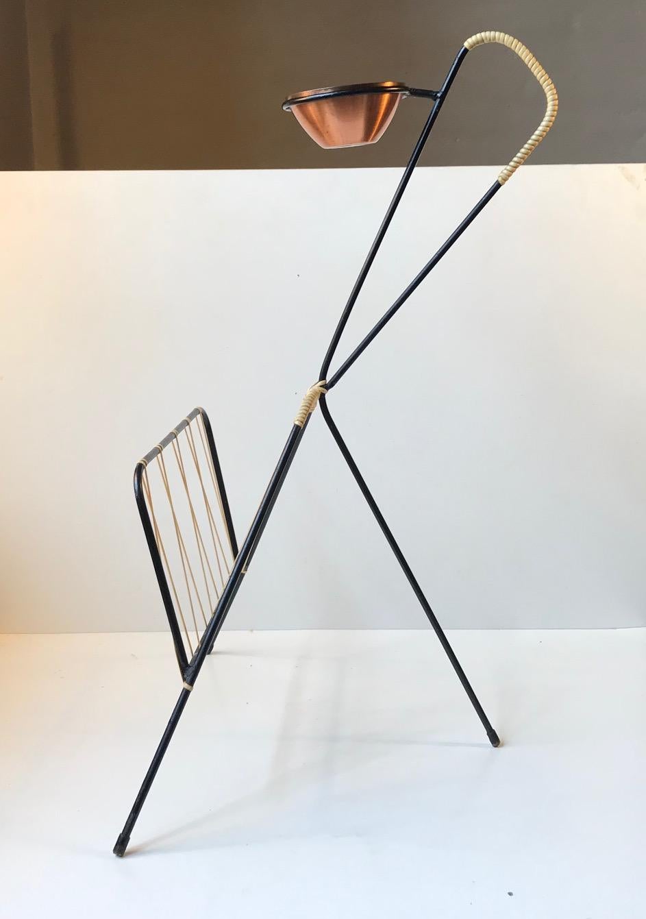 A graphic looking magazine rack with a removable bowl or ashtray in partially anodized copper from Corona, Denmark. Its commonly called the Giraffe due to its shape. The body is constructed from bend wire/string iron painted in black and with