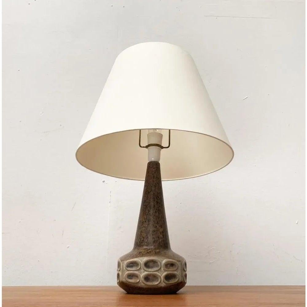 Ceramic table lamp from the Danish manufacturer Michael Andersen after a design by Marianne Stark from the 1960s.

The slim shaft of the ceramic foot widens into a square foot with soft radii down to a square foot. The proportion from foot to shaft