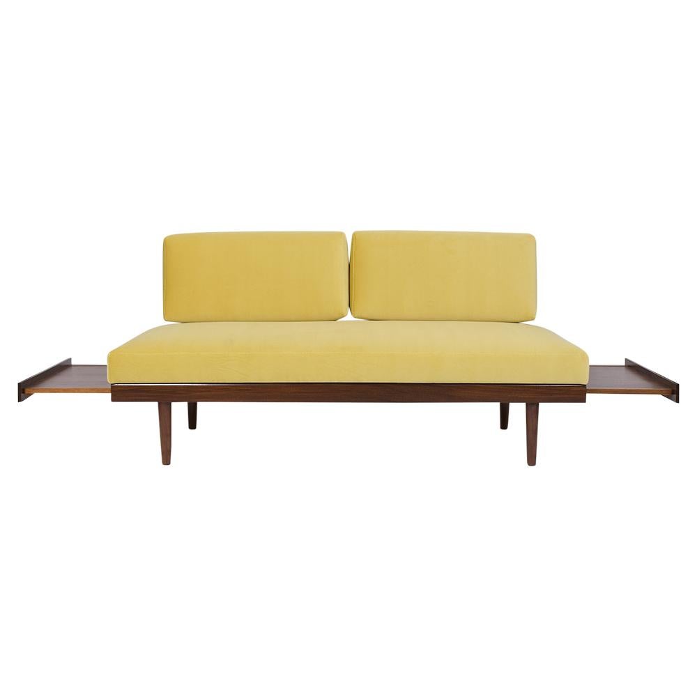 This elegant 1960's Modern Velvet Sofa is professionally crafted out of walnut wood is newly stained in a dark walnut color with a lacquered finish and has been completed restored. The frame features a slatted backrest, two pull side tables and the