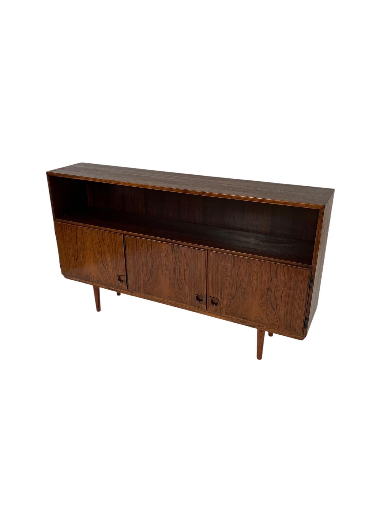 Striking vintage mid-century modern credenza featuring beautiful wood grain, sculpted circular pulls, and clean, minimal lines. The open shelf offers space to display decor or media, while the 3-door cabinet below provides generous concealed