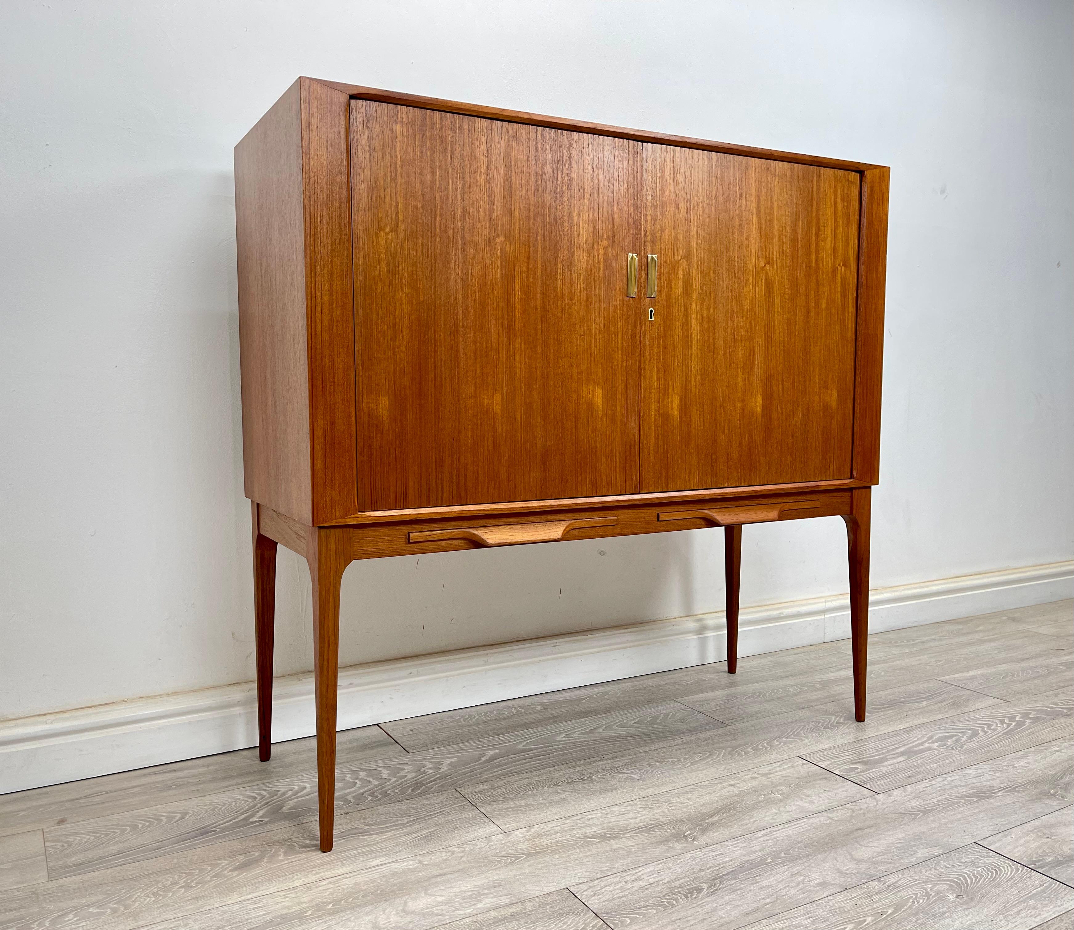 DRINKS BAR 
A stunning mid century danish teak tambour door cocktail cabinet / drinks bar circa 1960 . 
The cocktail cabinet  has stunning grain and golden patina throughout , there’s two pullout serving trays , with plenty of storage inside for