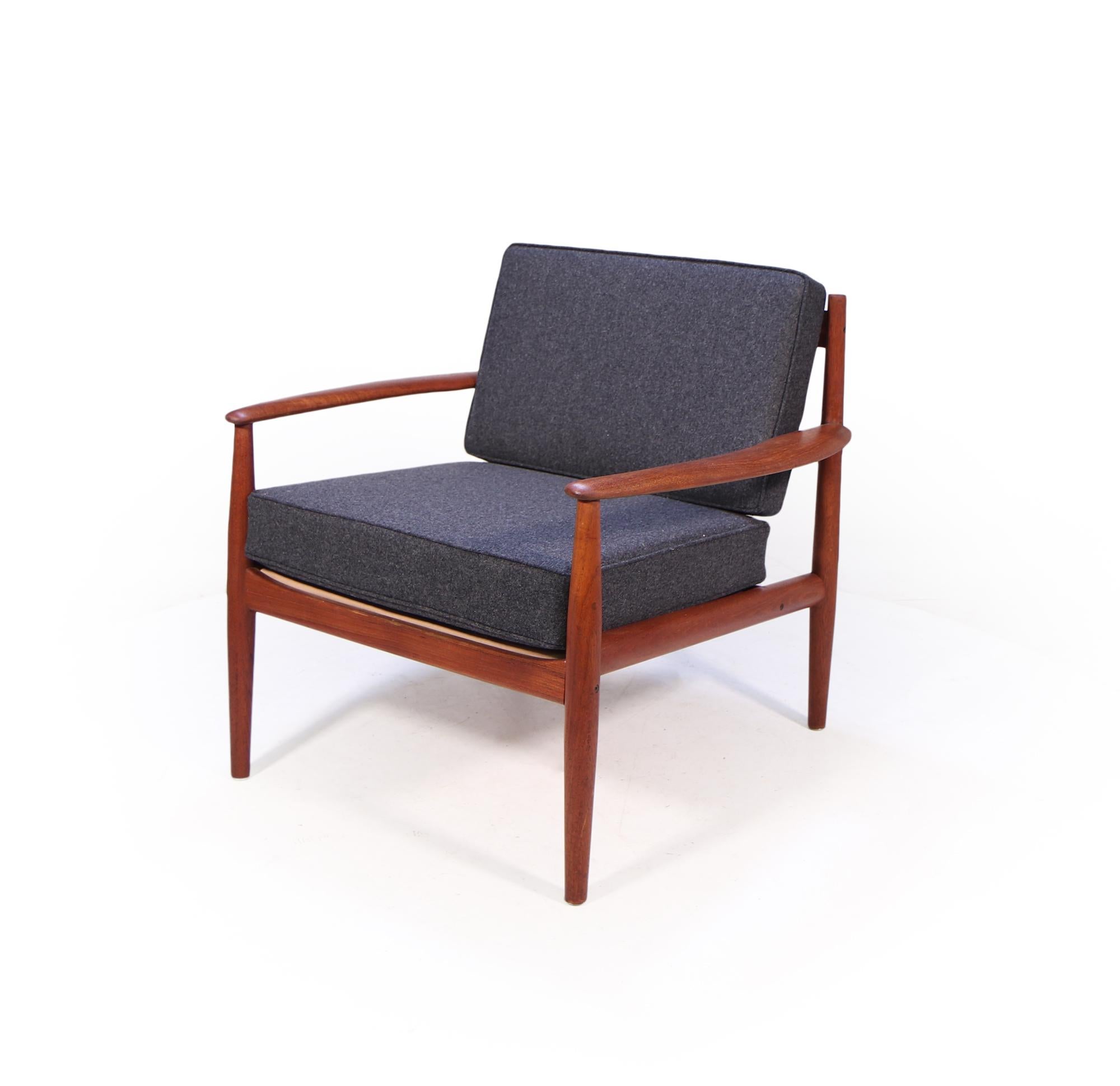 This Teak armchair was designed by Grete Jalk in 1963 and produced by renowned cabinetmakers France and Son. The chair has been restored where necessary and been fully re finished, this has had replacement cushions and covered in charcoal grey wool