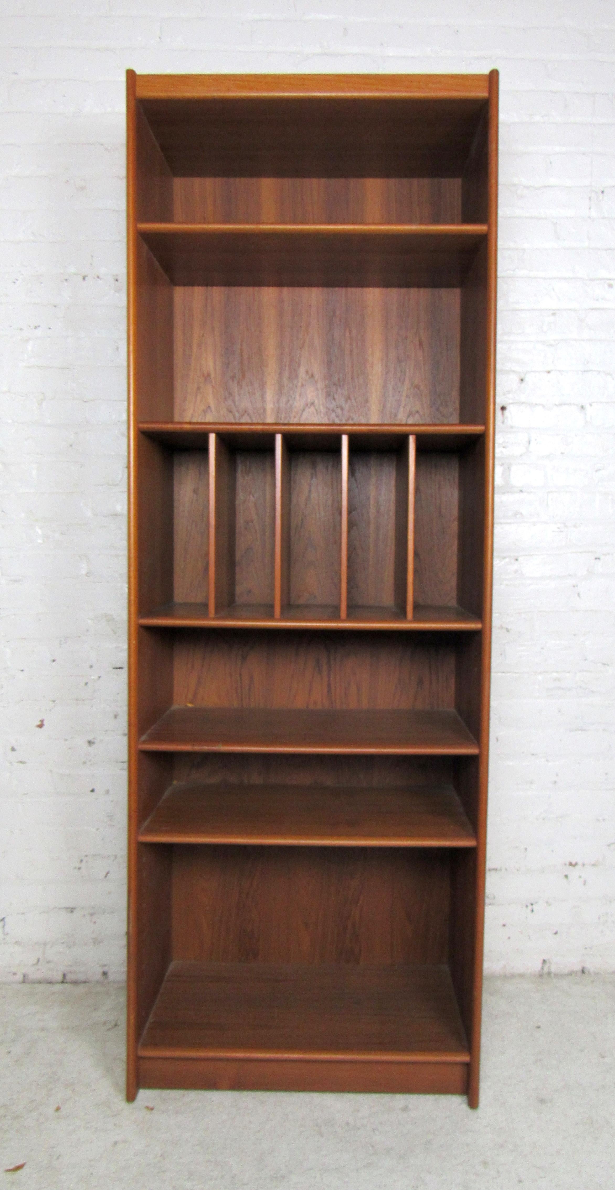 Vintage modern bookcase featured in rich teak wood grain and veneer.
The center section has great storage for records or documents.

Please confirm item location (NY or NJ).