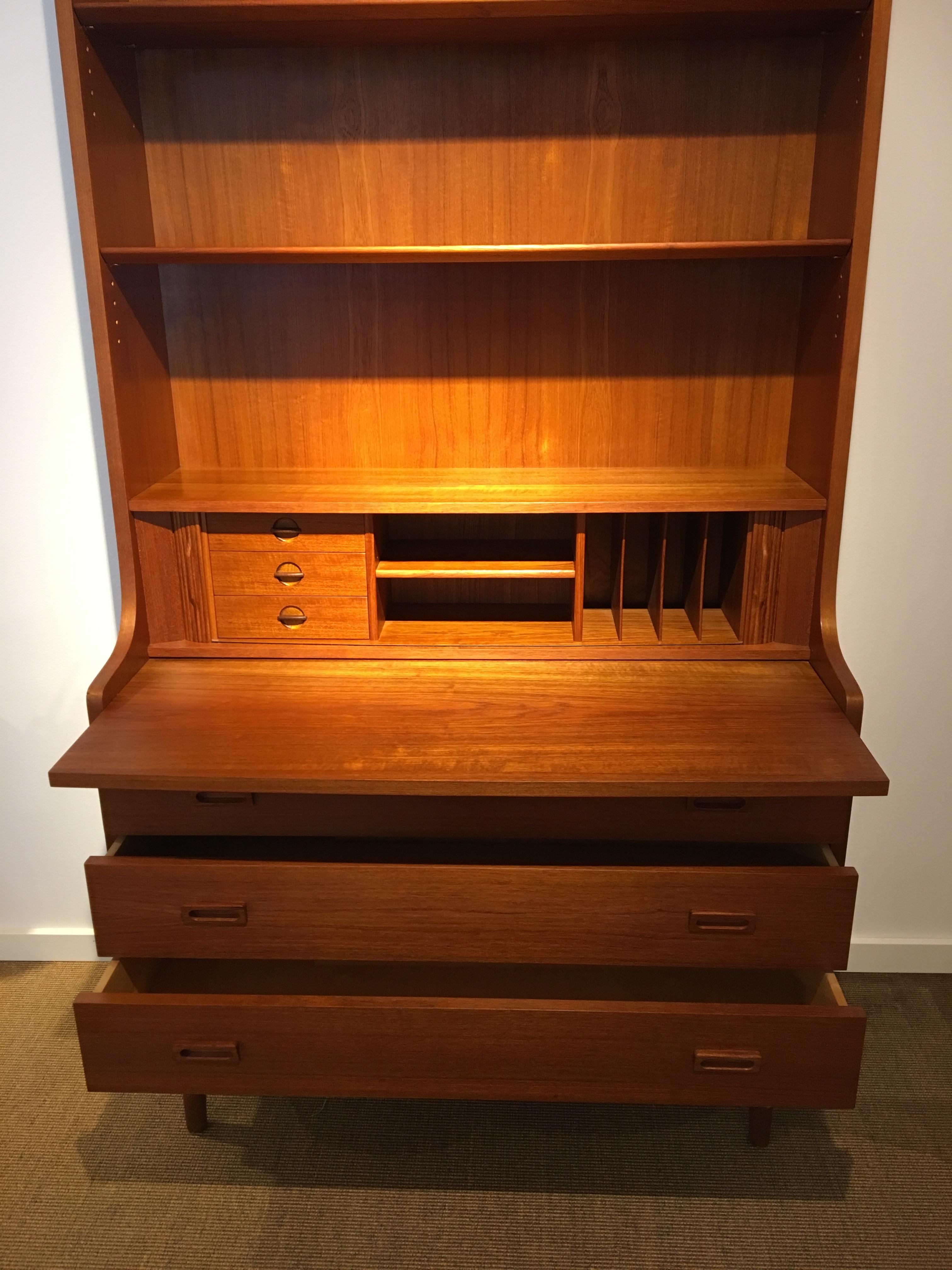 Midcentury Danish teak cabinet by Johannes Sorth, 1960s.
Nexø teak shelf in veneer. Design: Johannes Sorth. The lower part has 3 drawers, where the top drawer is divided. Extension plate over drawers and small louvre cover with 3 small drawers a