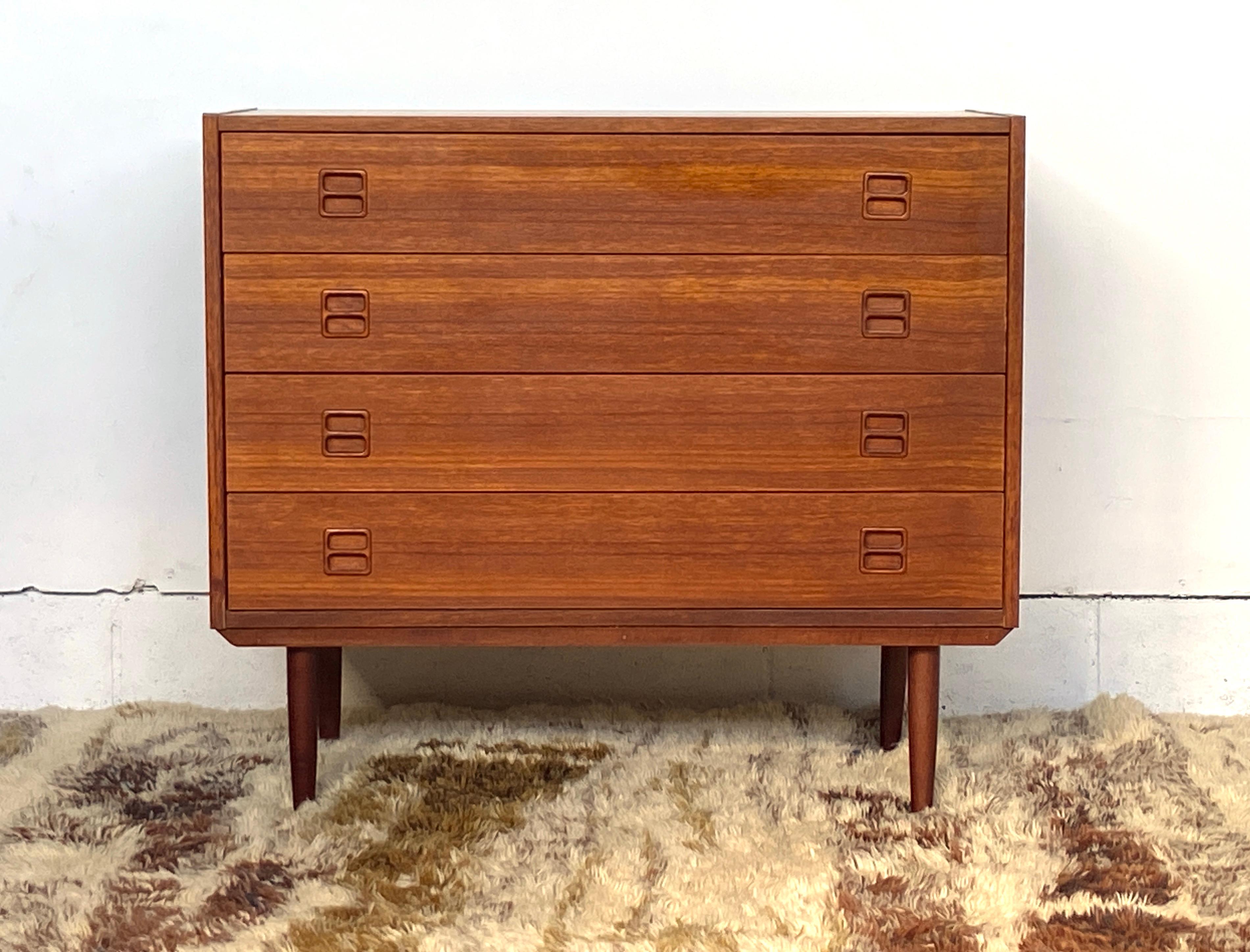 Mid century Danish teak dresser chest with four drawers and inlad pulls, good vintage condition. Attributed to N. P. Nielson, but similar to some Erik Brouer designs of the period.