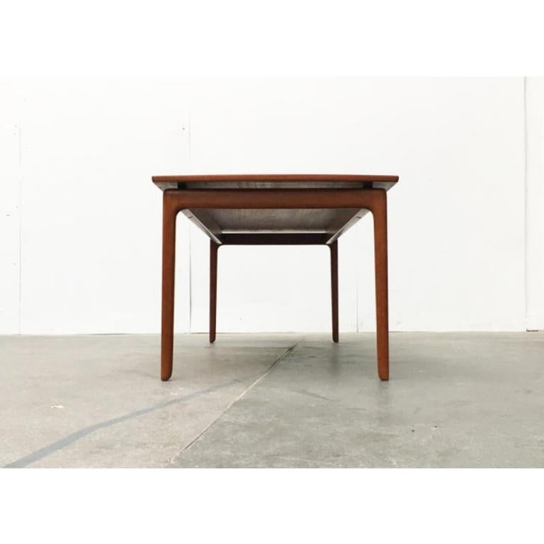 Original Danish teak coffee table by Poul Jeppesen, designed by Ole Wanscher from the 60s.

Plain teak table of high material and processing quality. The rectangular tabletop is optically decoupled from the frame and creates a floating effect over