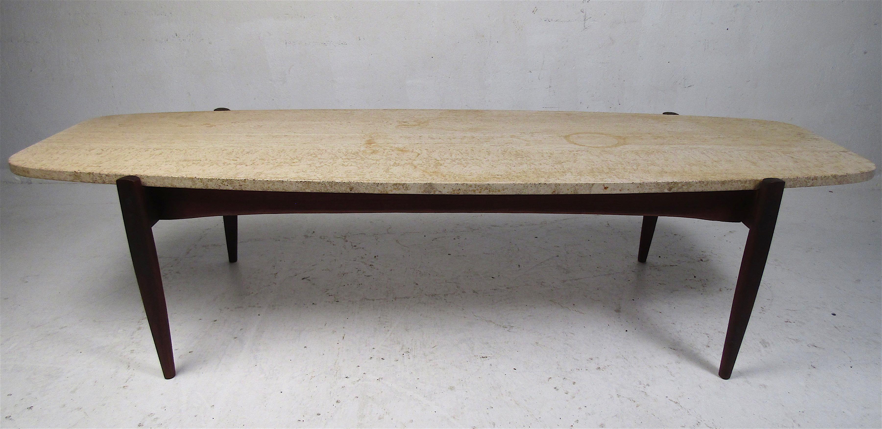 This stunning vintage modern coffee table boasts a uniquely shaped travertine top and a teak base with sculpted legs. A Danish design that looks great in any modern interior. Please confirm item location (NY or NJ).