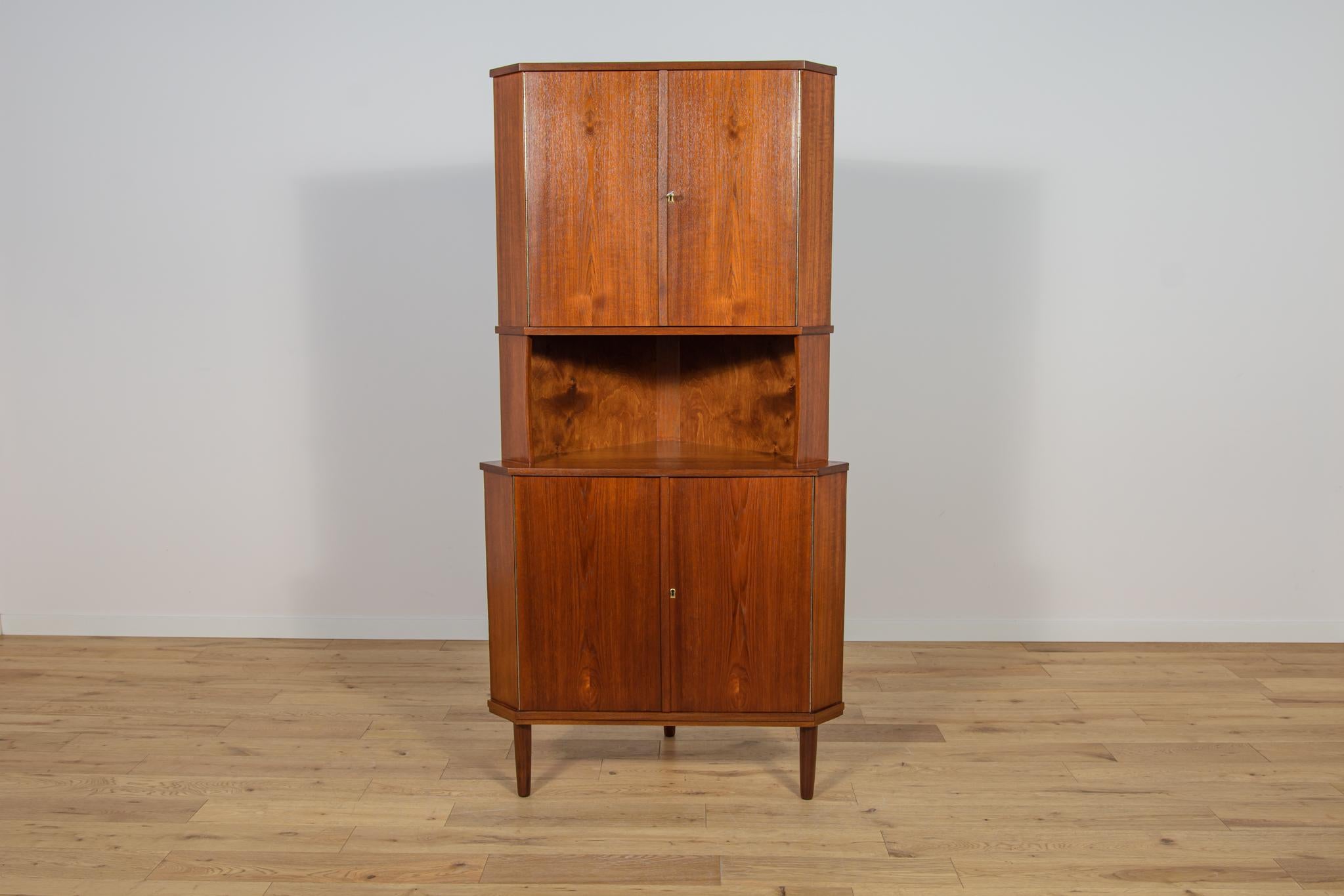 Il mobile ad angolo è stato realizzato in Danimarca negli anni '60. Mobile in teak. Un mobile con la classica soluzione delle ante apribili, grazie alla quale abbiamo accesso all'intero interno del mobile. All'interno dell'armadio ad angolo sono