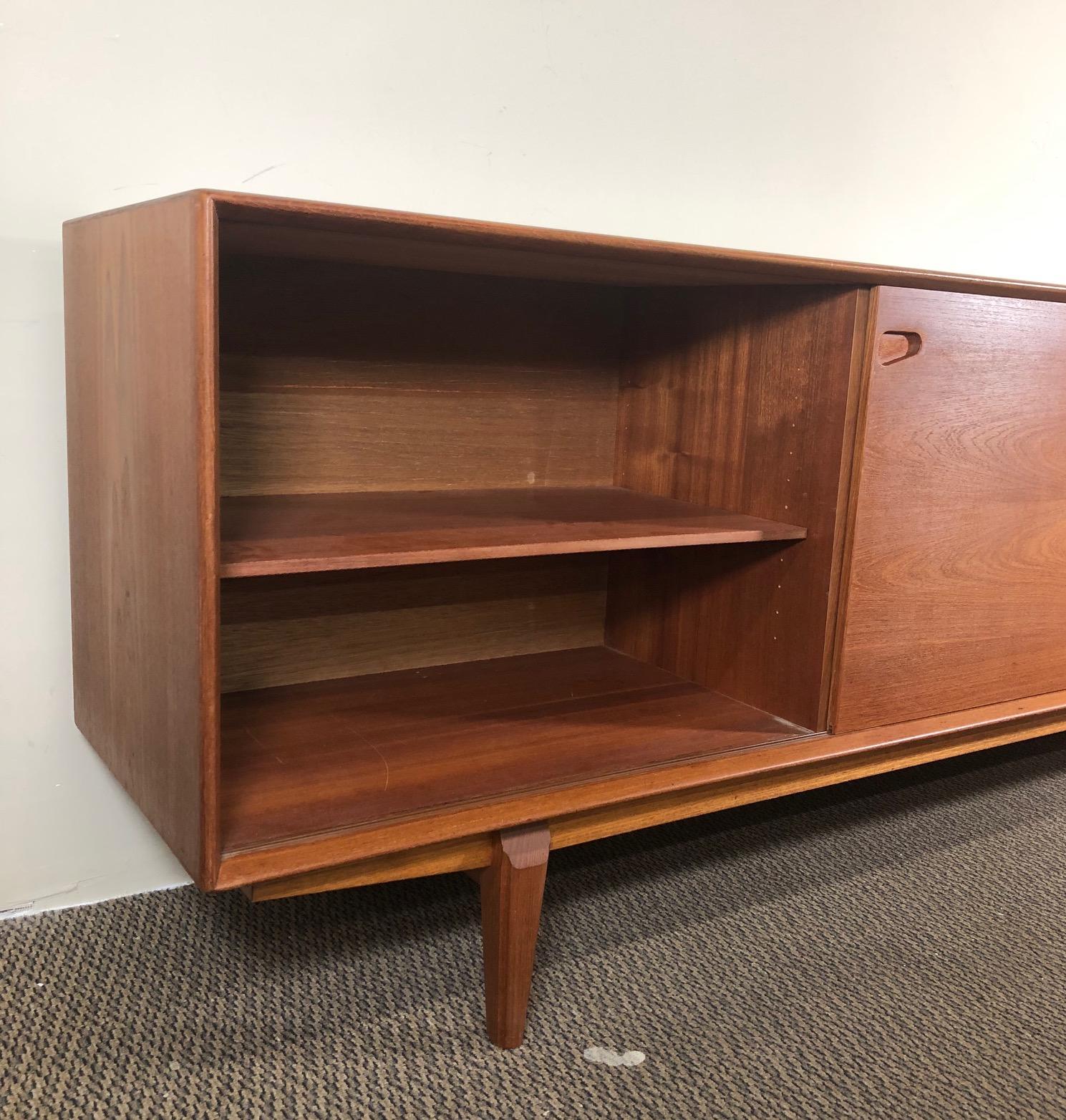 This is a beautiful Danish teak credenza with sliding doors with shelves and 5 center drawers.

Designed by Rosengren Hansen and made by Dyrlund. Made in Denmark. Original manufacturer label inside the credenza.

Very good unaltered original