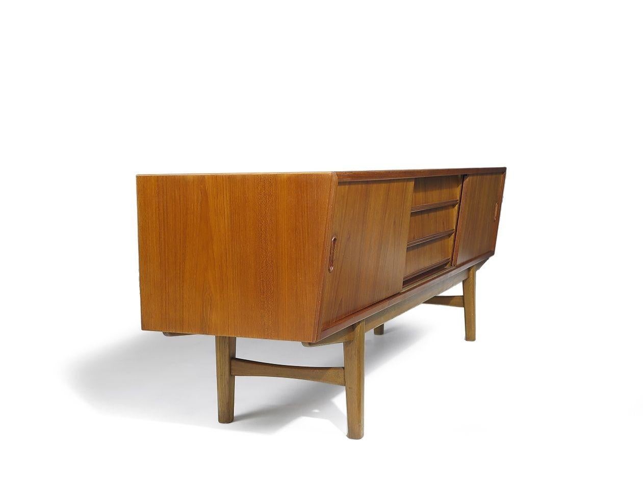 A olio Credenza danese di metà secolo in teak con fronte angolare e ante scorrevoli in vendita