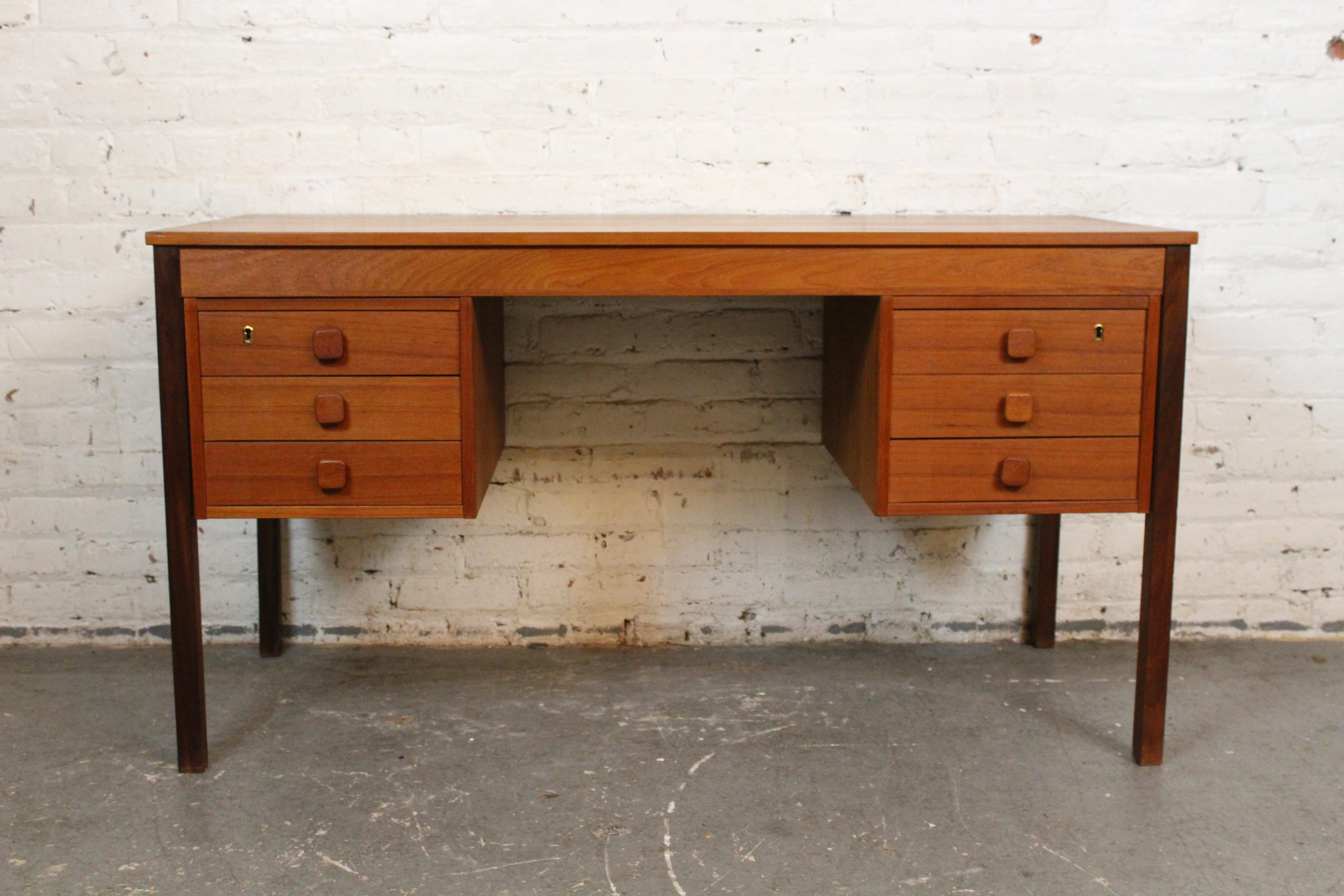 Discover the form and function of genuine mid-century Danish design with this classic Scandinavian Modern desk produced by Domino Møbler of Denmark. With its timeless, simple silhouette, it boasts an ample 53”x23” desktop providing space to tackle