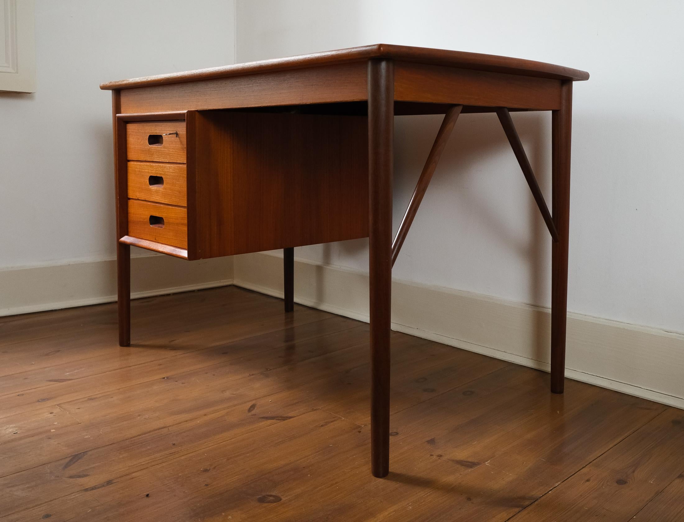 For sale is a stunning Mid-Century Modernist Danish Teak Desk designed by Erik Buch for Oddense Maskinsnedkeri AS, circa 1960s.

The desk, which comprises three drawers, one with a lock & key, and a display shelf on the front side, is in good