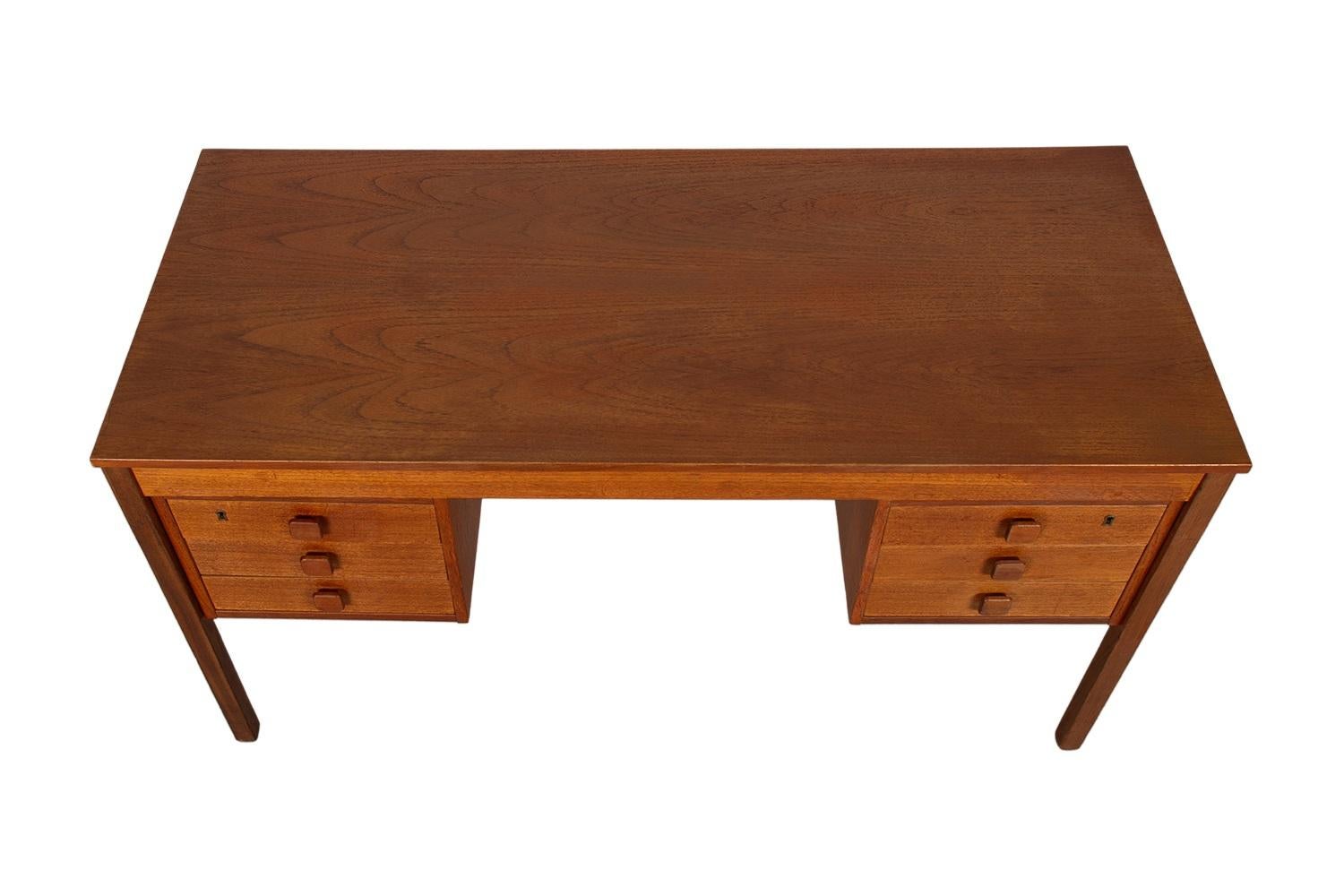Una bellissima dichiarazione di design e artigianato. Questa scrivania danese in teak della metà del secolo scorso, realizzata con precisione in un eccezionale legno con venature di teak, con un retro completamente rifinito, rende questa scrivania