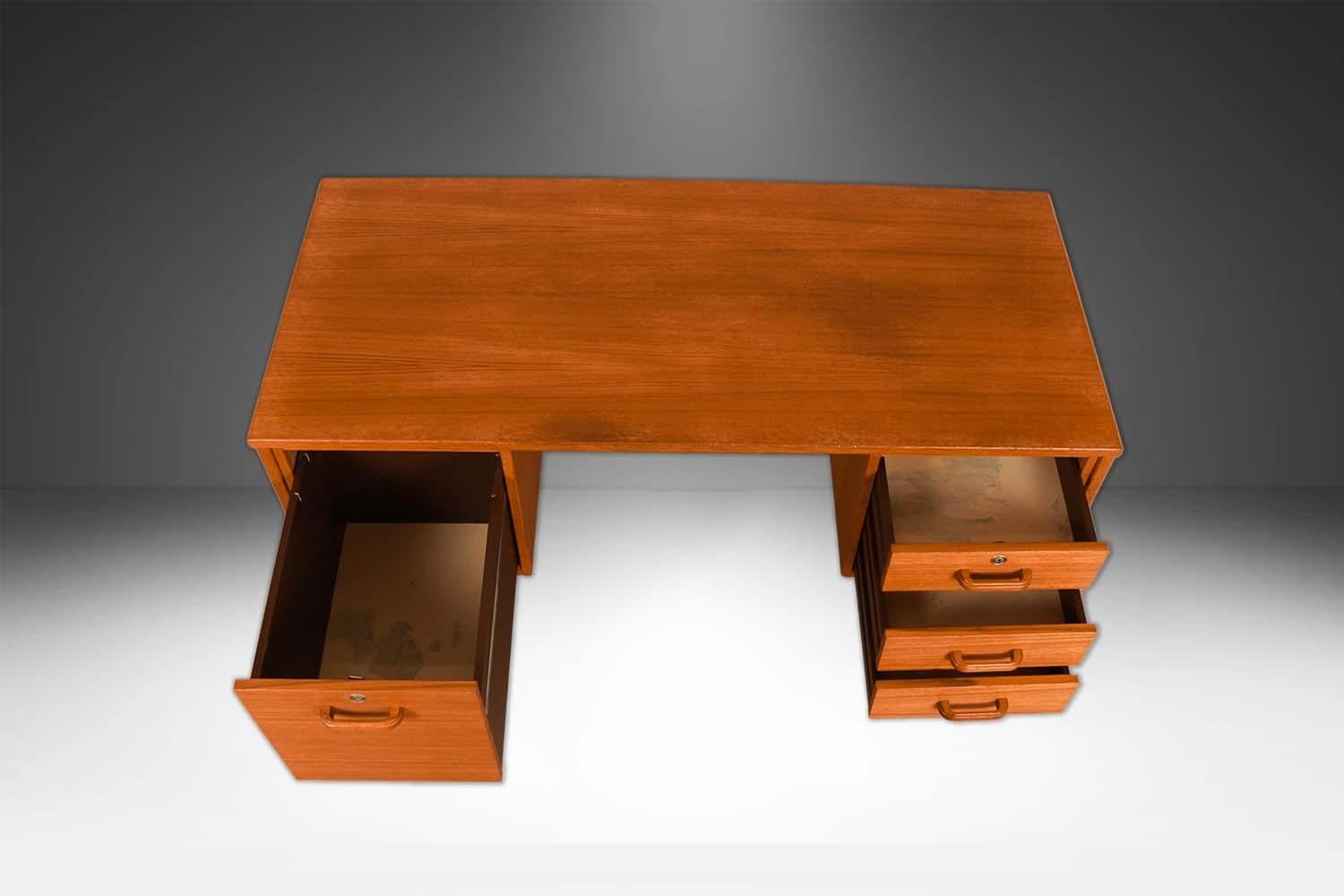 Beautiful remarkable statement in design and craftsmanship. This mid-century teak Danish desk, precisely crafted in exceptional teak grain wood, with a fully finished back the finished back side makes this desk ideal for placement in an open floor
