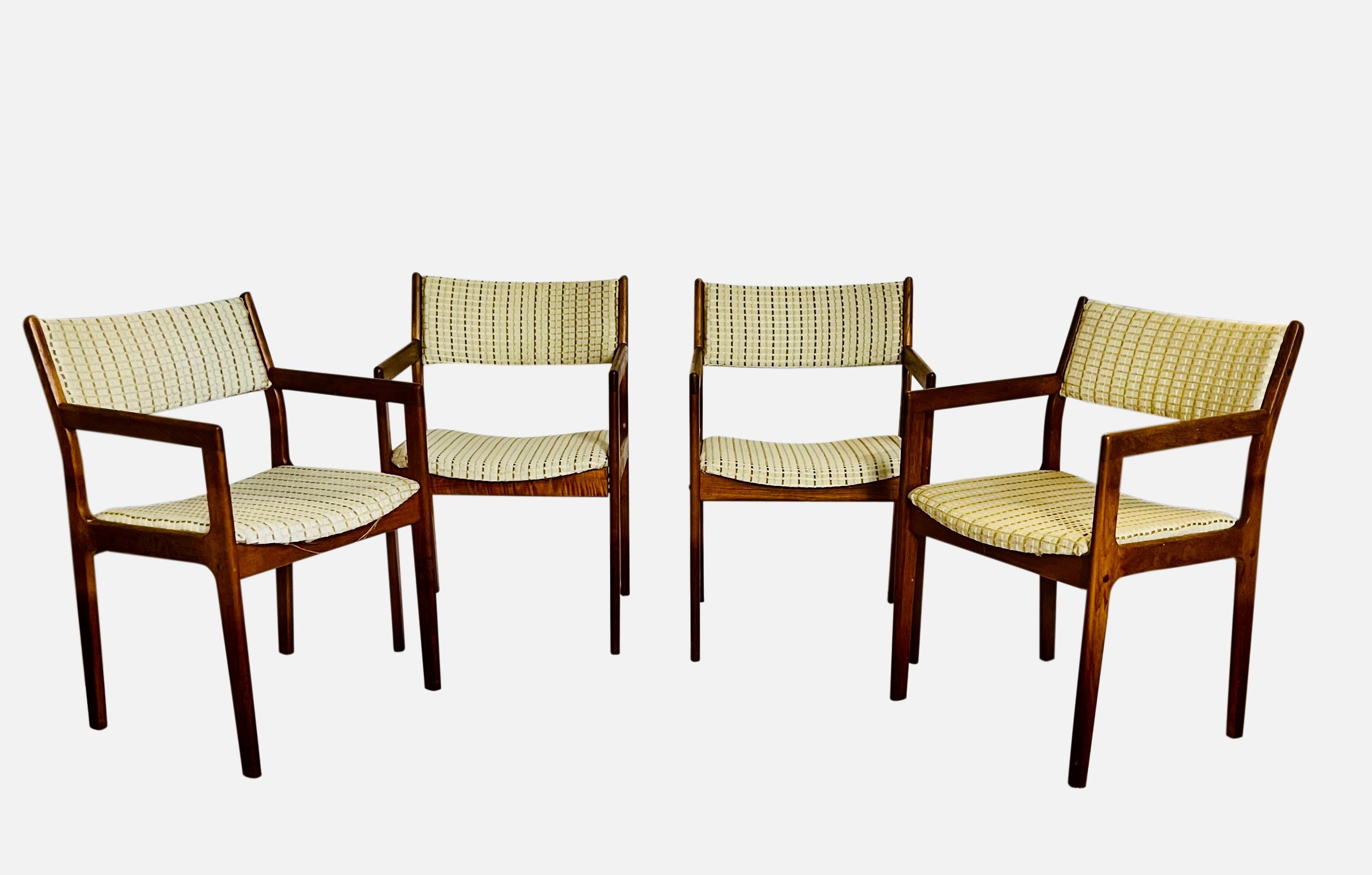 Set of four midcentury Danish dining chairs in teak. 

All chairs feature arms which create a sleek silhouette and provide comfort. The upholstered back and seat are in a subtly textured neutral with cream, ice blue and olive brown. Fabric is in