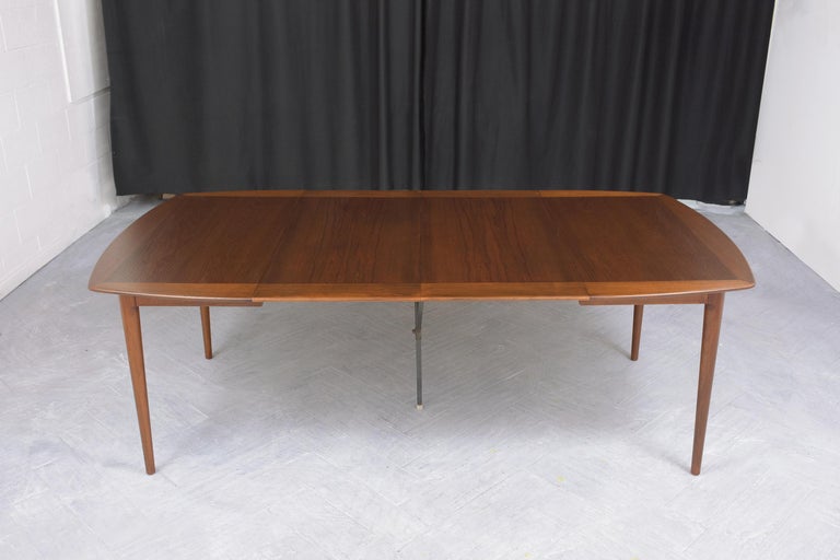 This extraordinary vintage 1960s mid-century modern danish teak dining table is in excellent condition and is hand-crafted out of teak wood and veneer combinations newly restored by our expert professional craftsmen team. This table is eye-catching