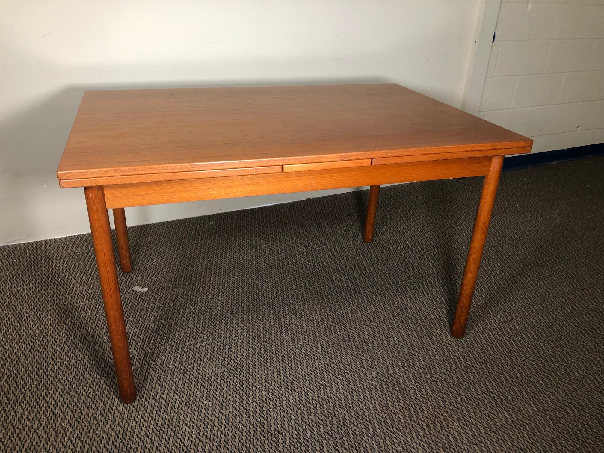 Draw leaf teak dining table. 

Very good original condition. Leaves slightly darker than the tabletop because they were not used as much as the main tabletop. Some marks on the legs as shown in photos.

The leaves are stored underneath the table