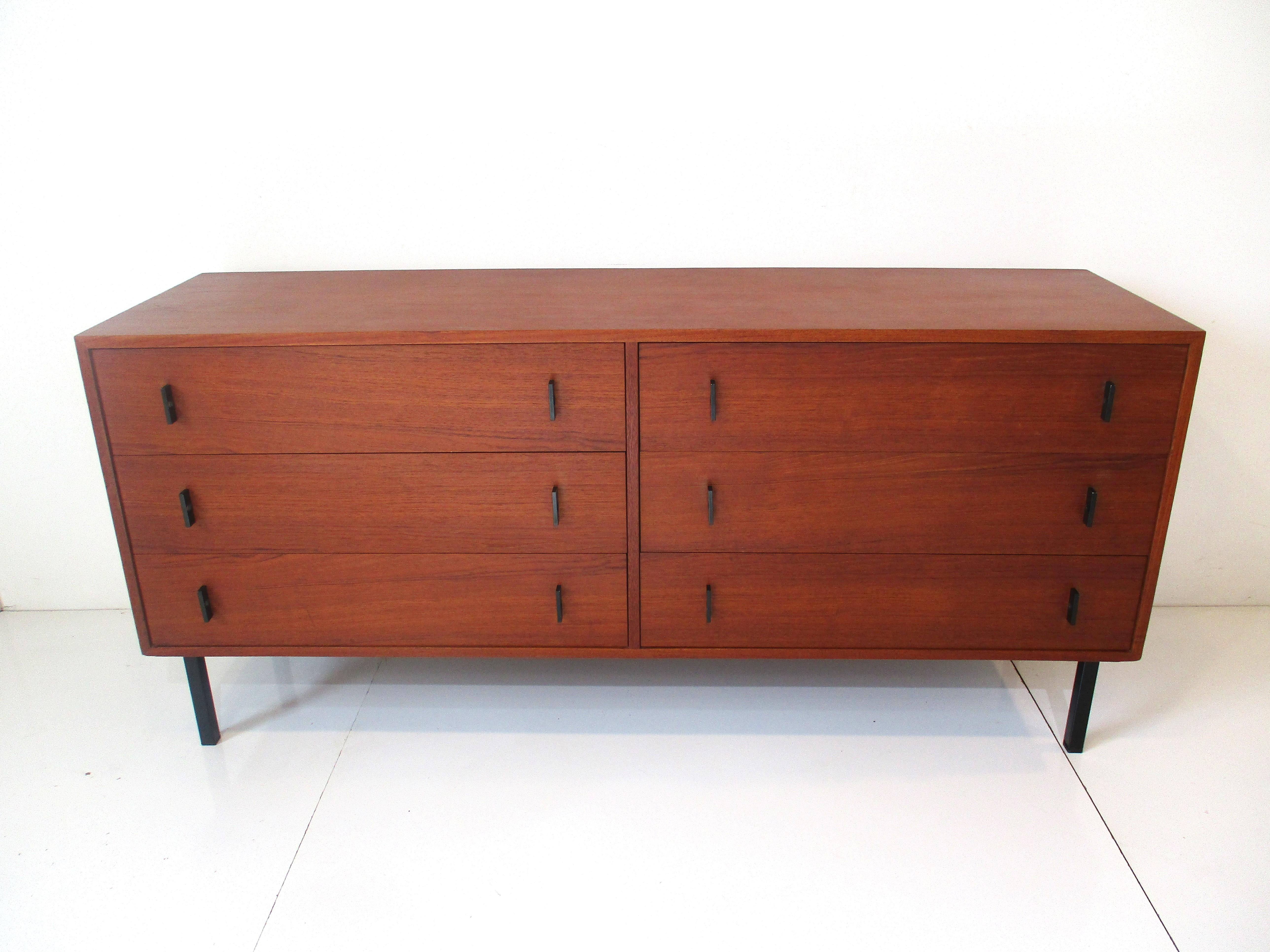 A very well crafted Danish medium dark teak wood six drawer dresser with great graining, stain black metal legs and pulls. Inside it has the contrasting light colored birch wood drawers with dovetail construction.