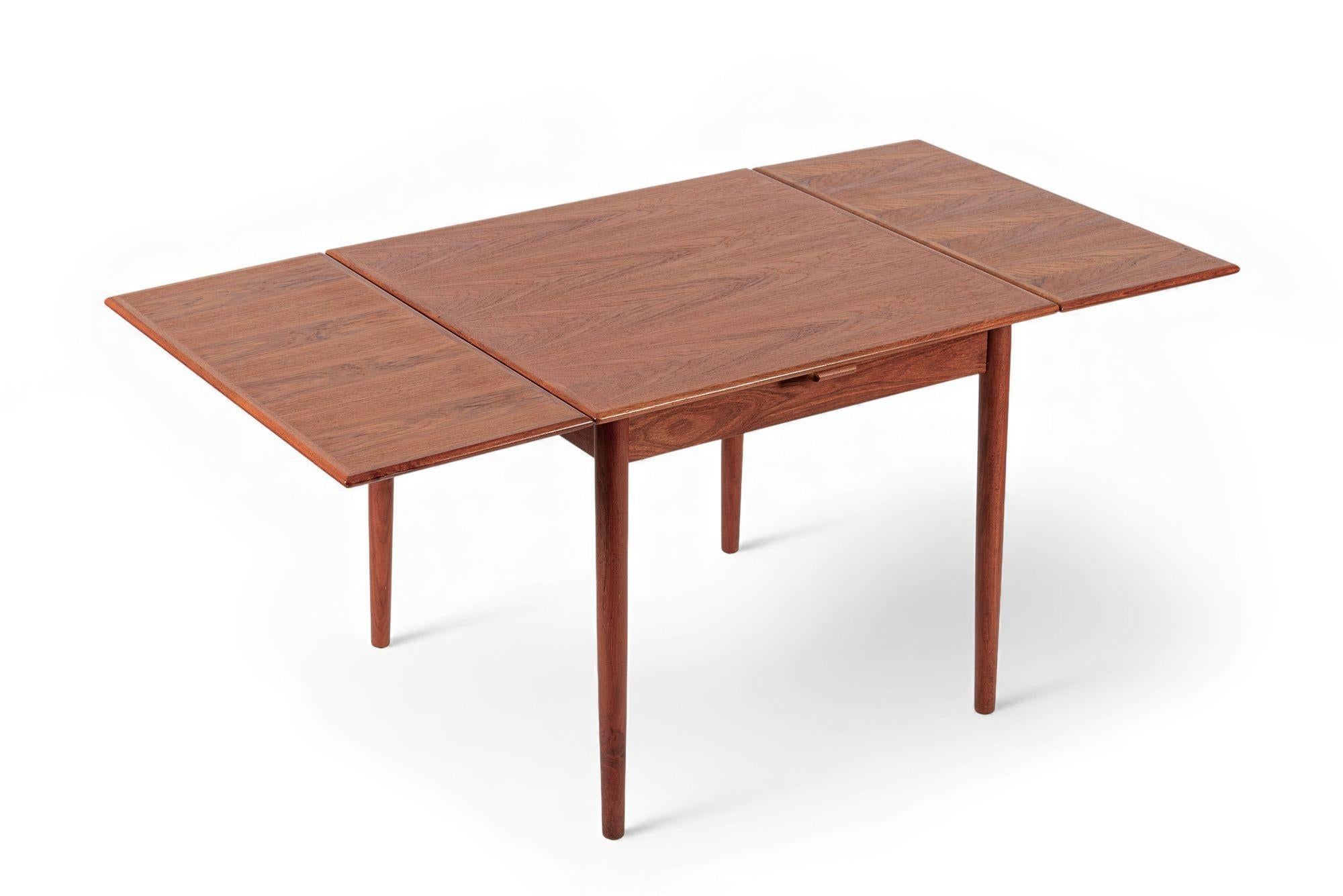 This lovely vintage mid century Danish modern extendable teak dining table was designed by Poul Volther for Frem Rojle and made in Denmark circa 1960. The dining table is well-constructed and has a classic Scandinavian modern design with clean,