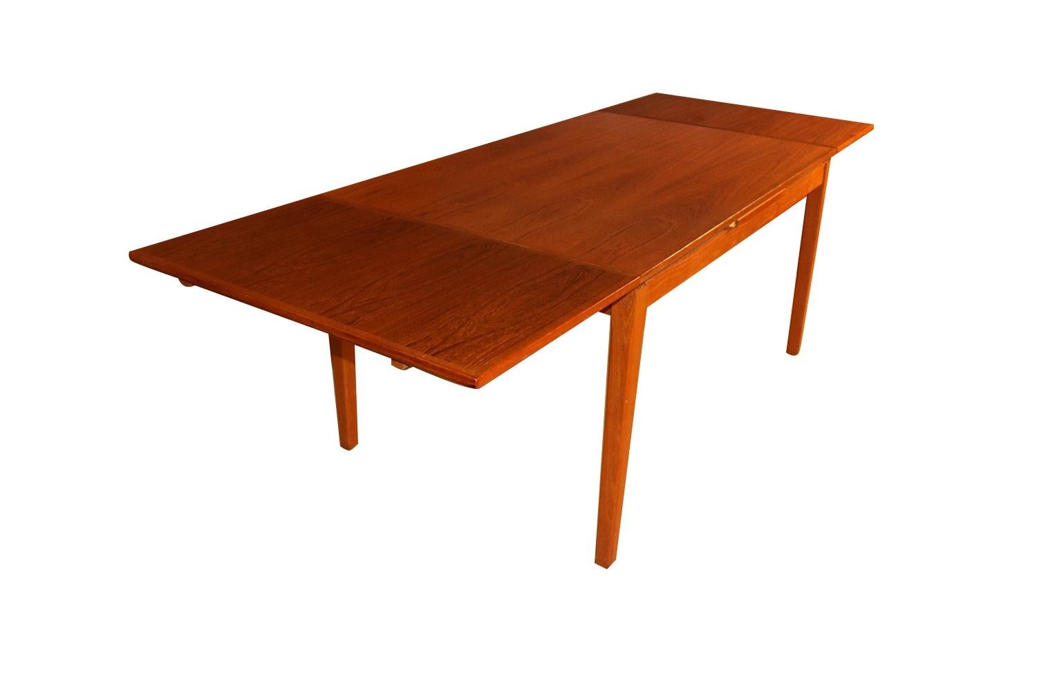Exceptional Danish modern teak extension dining table produced by H. Sigh & Son’s Mobelfabrik in Denmark. This gorgeous Danish teak extending dining table remains in original good condition throughout. With an initial medium footprint, this table
