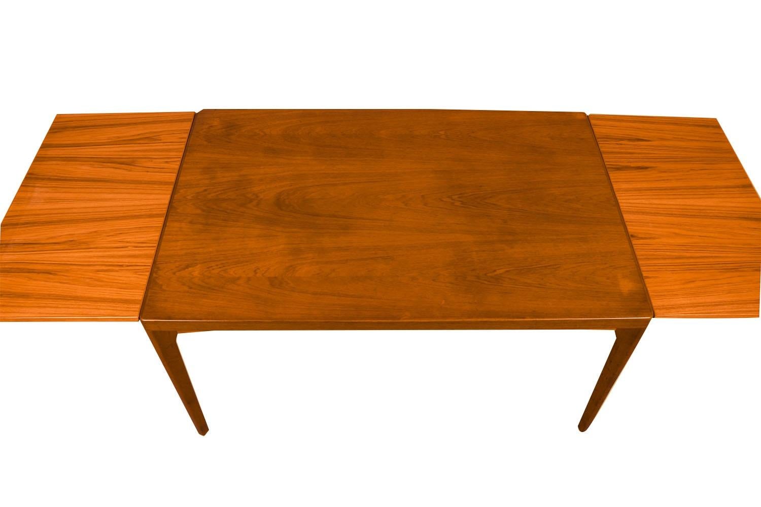 An exceptional Danish Modern teak extension dining table designed by Henning Kjaernulf for Vejle Stole og Møbelfabrik. With an initial large footprint, this table can also offer a generous space and double in size once its draw leaves are extended.