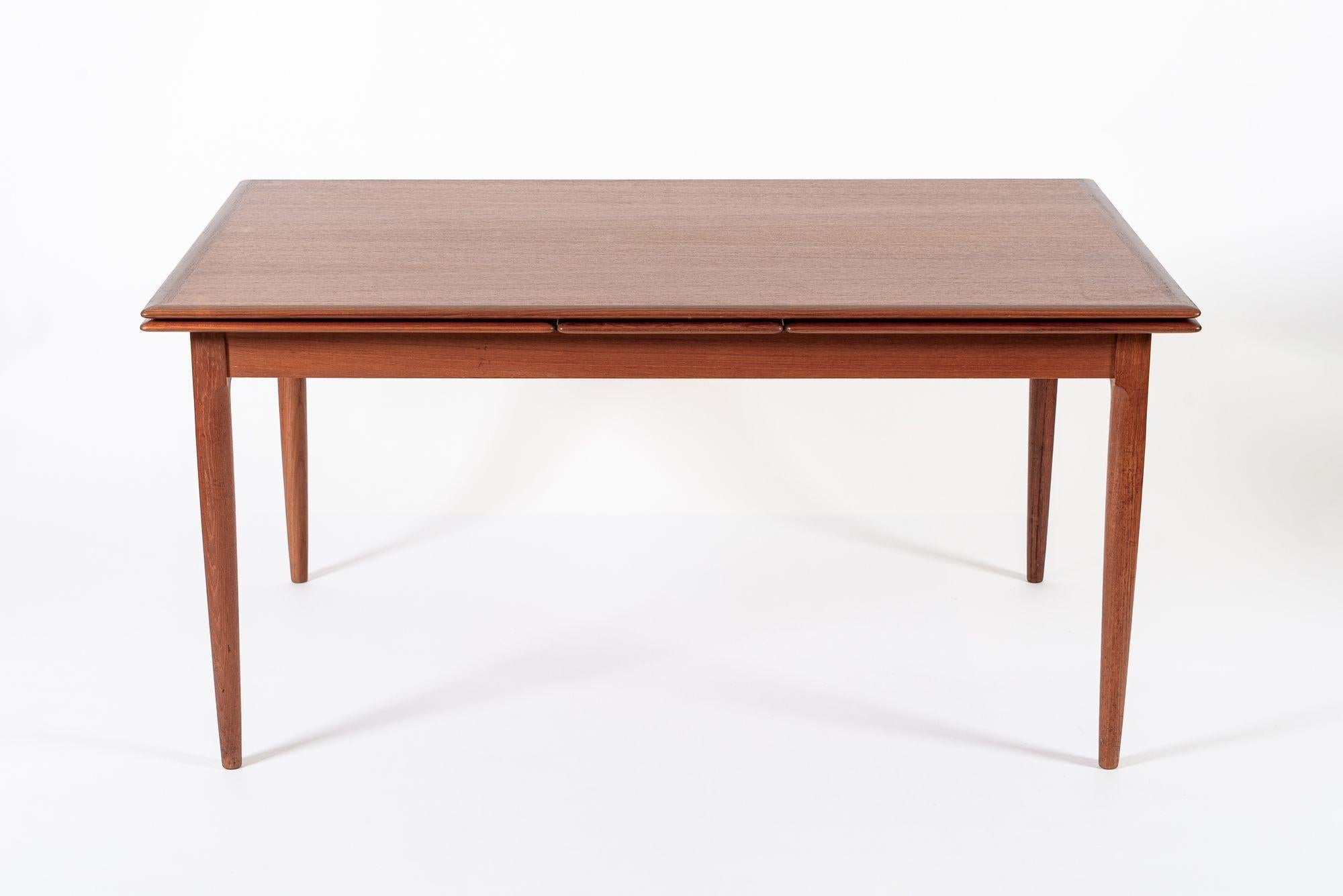 This exceptional vintage mid century Danish modern extendable teak dining table was designed by Kai Kristiansen for Korup Stolefabrik (attr.) and made in Denmark circa 1960. This beautiful table has clean, minimalist lines and is impeccably
