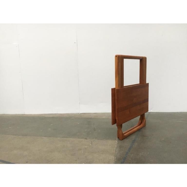 Mesa plegable de teca del fabricante danés Juul Kristensen.

Una mesa plegable práctica y elegante, totalmente de madera maciza de teca. Mediante un sencillo sistema de plegado, se despliega hasta convertirse en una mesa completa. Cuando está