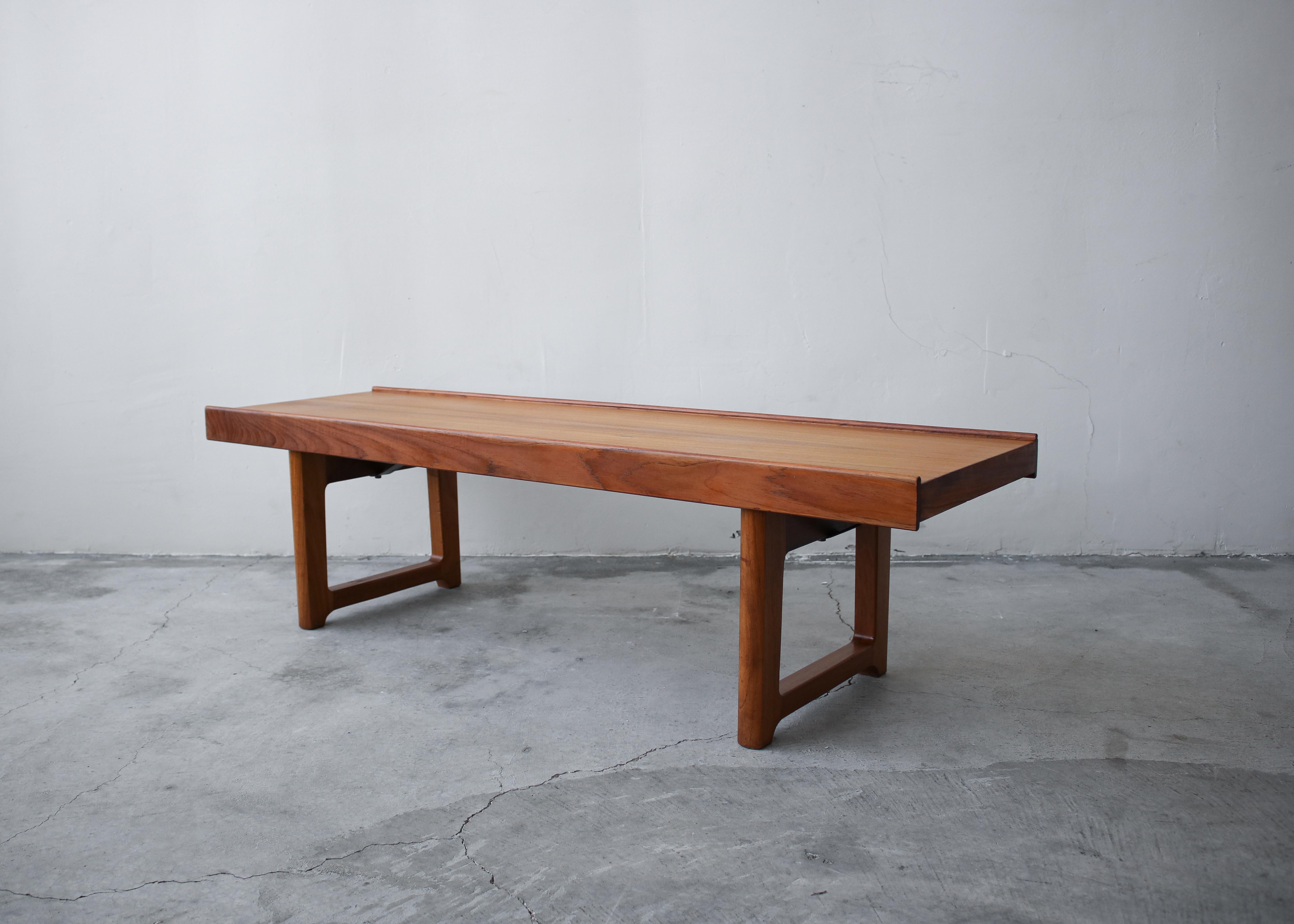 Original 1960s Danish teak Krobo bench by Torbjørn Afdal for Bruksbo. A simple yet versatile piece. Pretty enough to be used as mere decor but constructed with steel supports, so it can double as seating. The uses are endless.
 
See reference