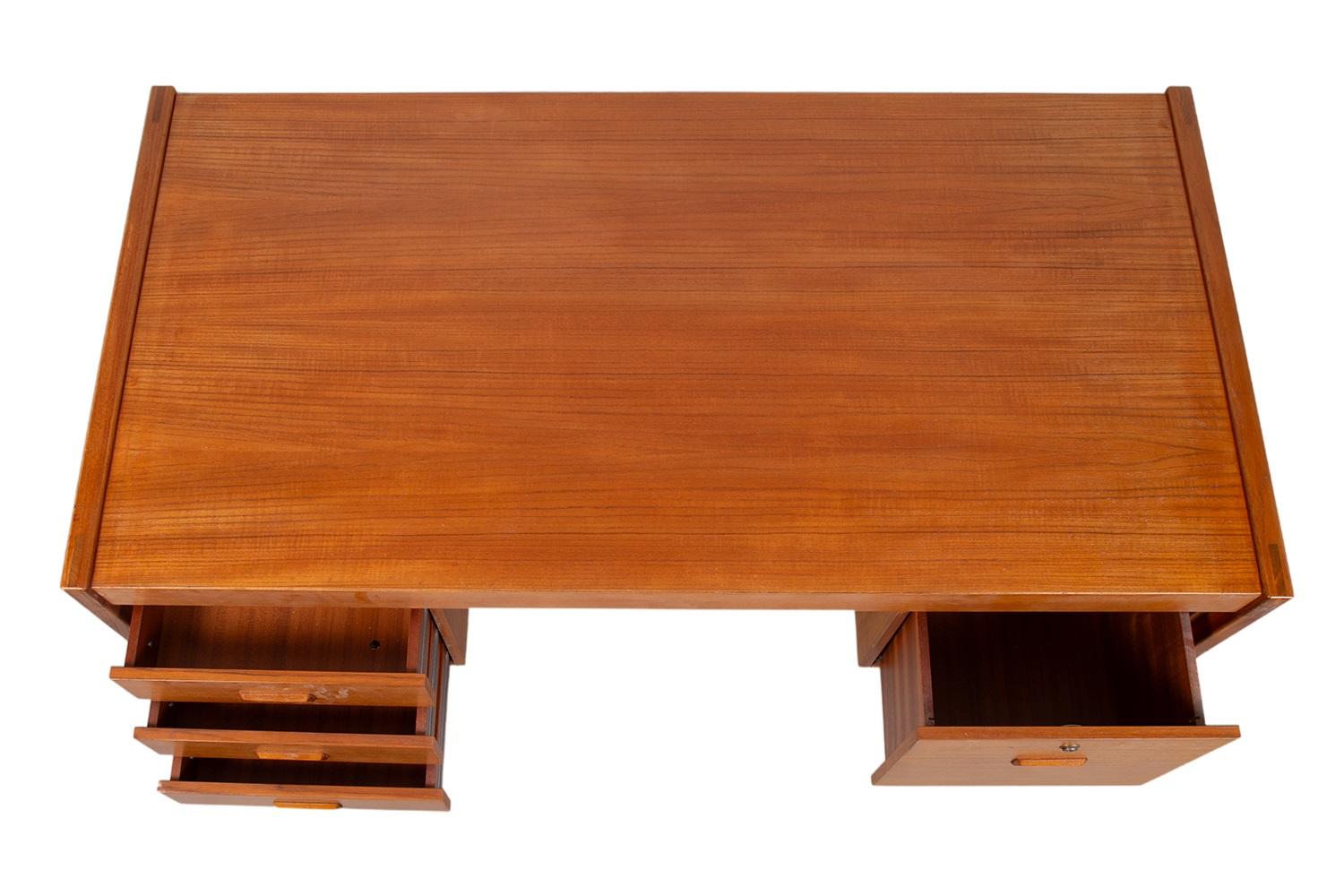 Una bellissima dichiarazione di design e artigianato. Questa grande scrivania danese in teak della metà del secolo scorso è realizzata con precisione in un eccezionale legno con venature di teak, con un retro completamente rifinito. Il lato