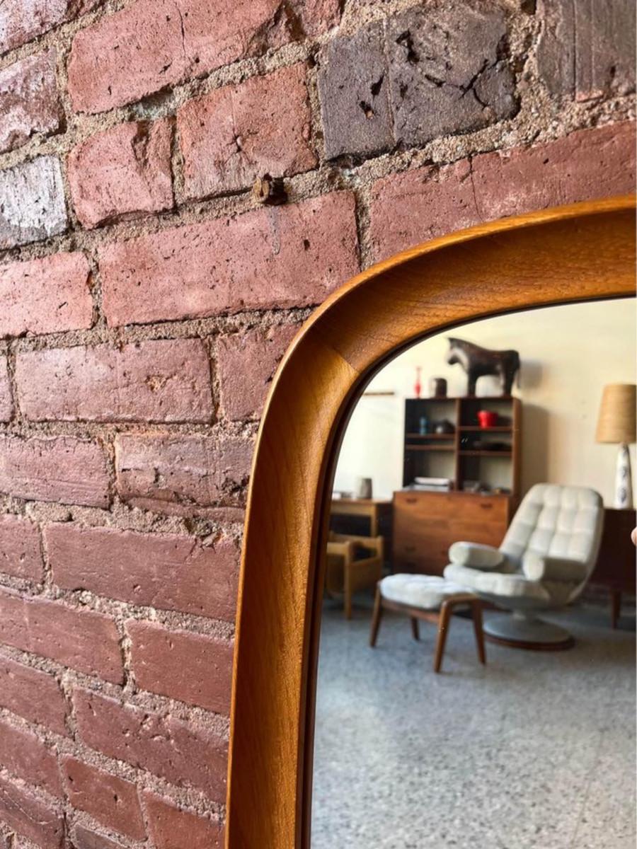 We are excited to offer this Danish teak mirror featuring a beautiful, uniquely shaped frame. Marvel at the curved edges that exude timeless elegance. With its impeccable craftsmanship, it’s a must-have statement piece for any setting.

17”