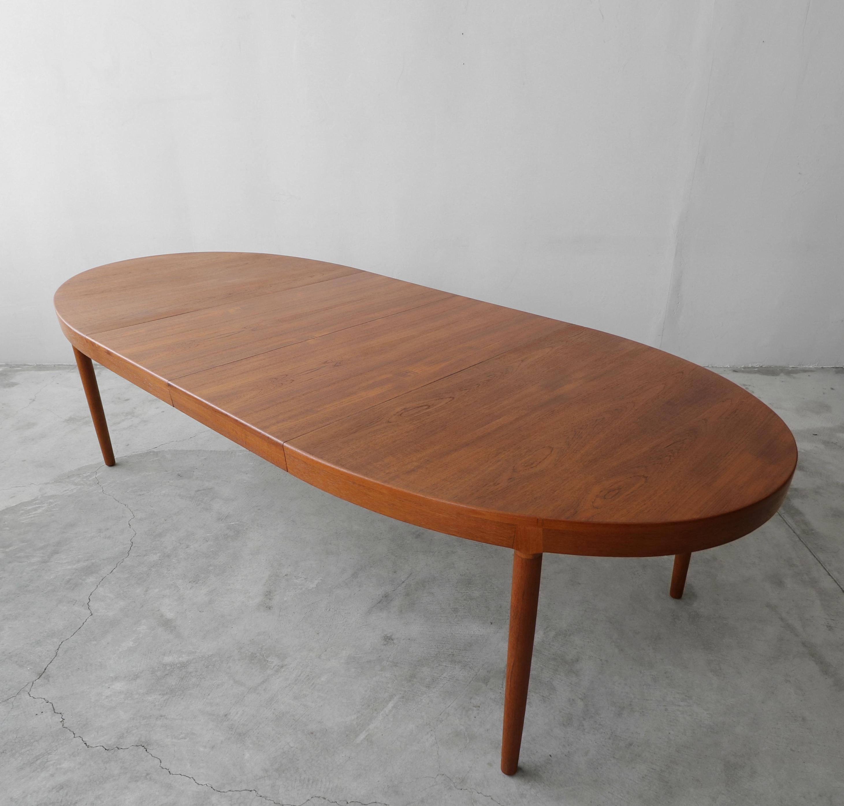 This a beautiful oval shaped Danish teak dining table by Harry Ostergaard for A/S Randers is both Classic in Danish design and very well made, with solid teak details. It has beautiful lines and gorgeous color. This table is a great size closed and