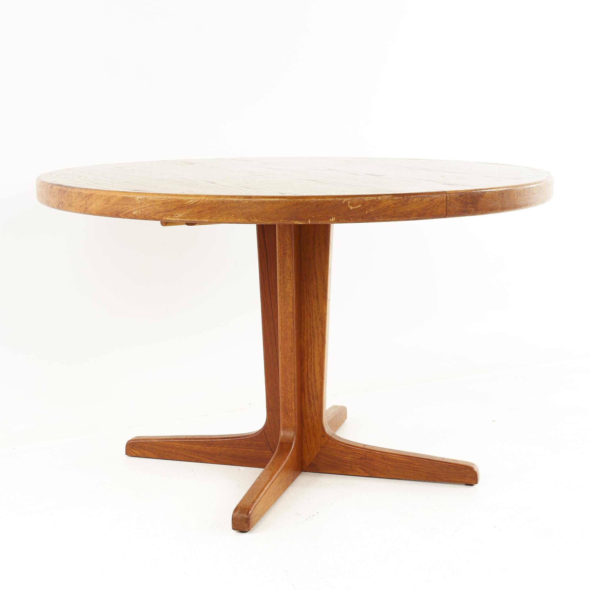 Mid century Danish teak round oval expanding dining table

The table measures: 47 wide x 47 deep x 29 high, with a chair clearance of 26.75 inches; each leaf is 19.75 inches wide, making a maximum table width of 86.5 inches when both leaves are