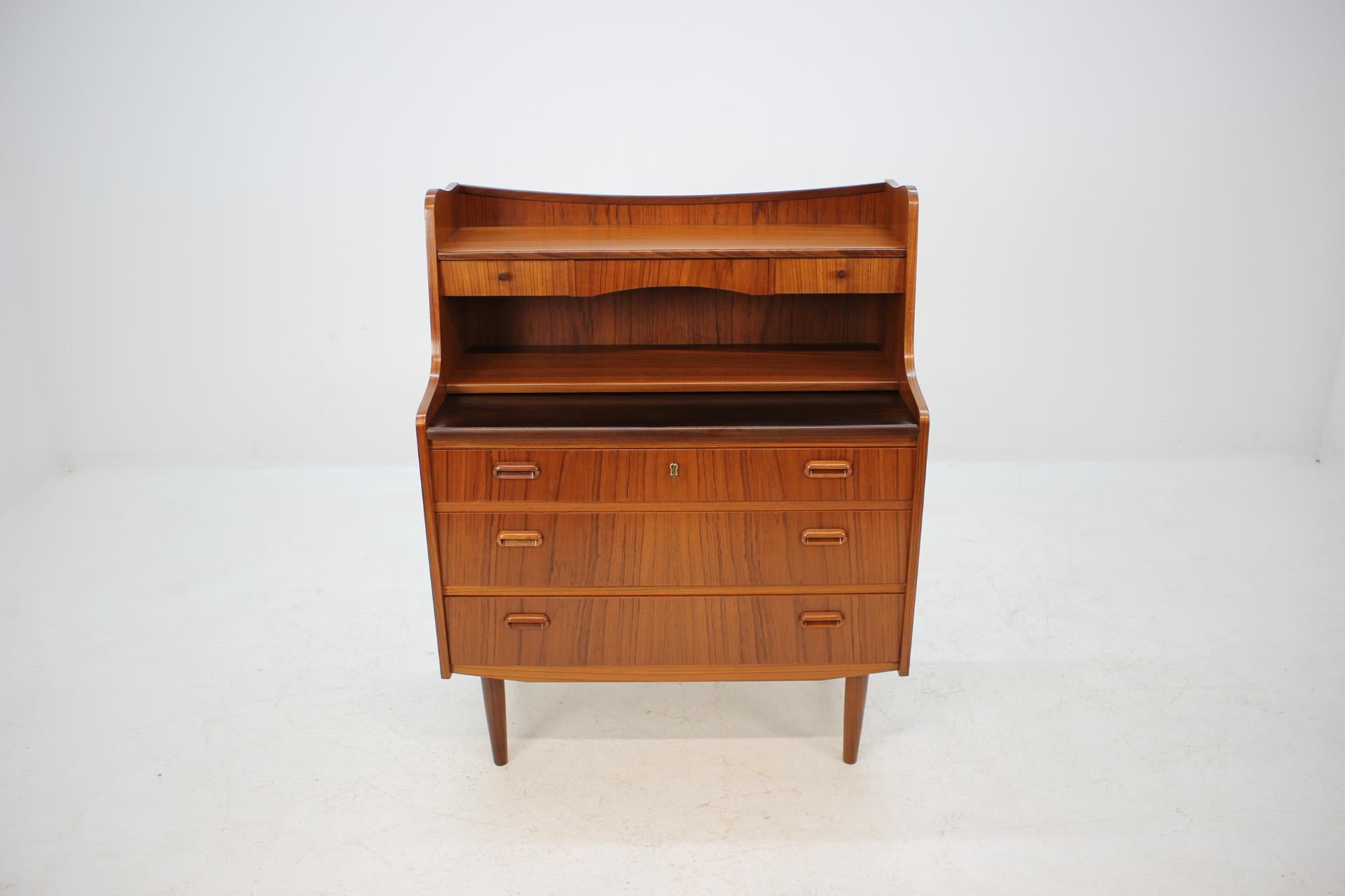 This Danish teak writing cabinet features three drawers and two small one. The extendable writing area desk can be extended up to 60 cm. This item was carefully refurbished.
