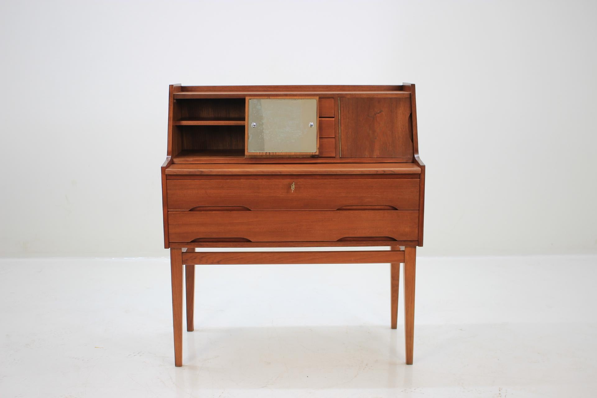 This Danish teak writing cabinet features mirror, two large drawers and three small one. The extendable writing area desk can be extended up to 71 cm. This item was carefully refurbished.