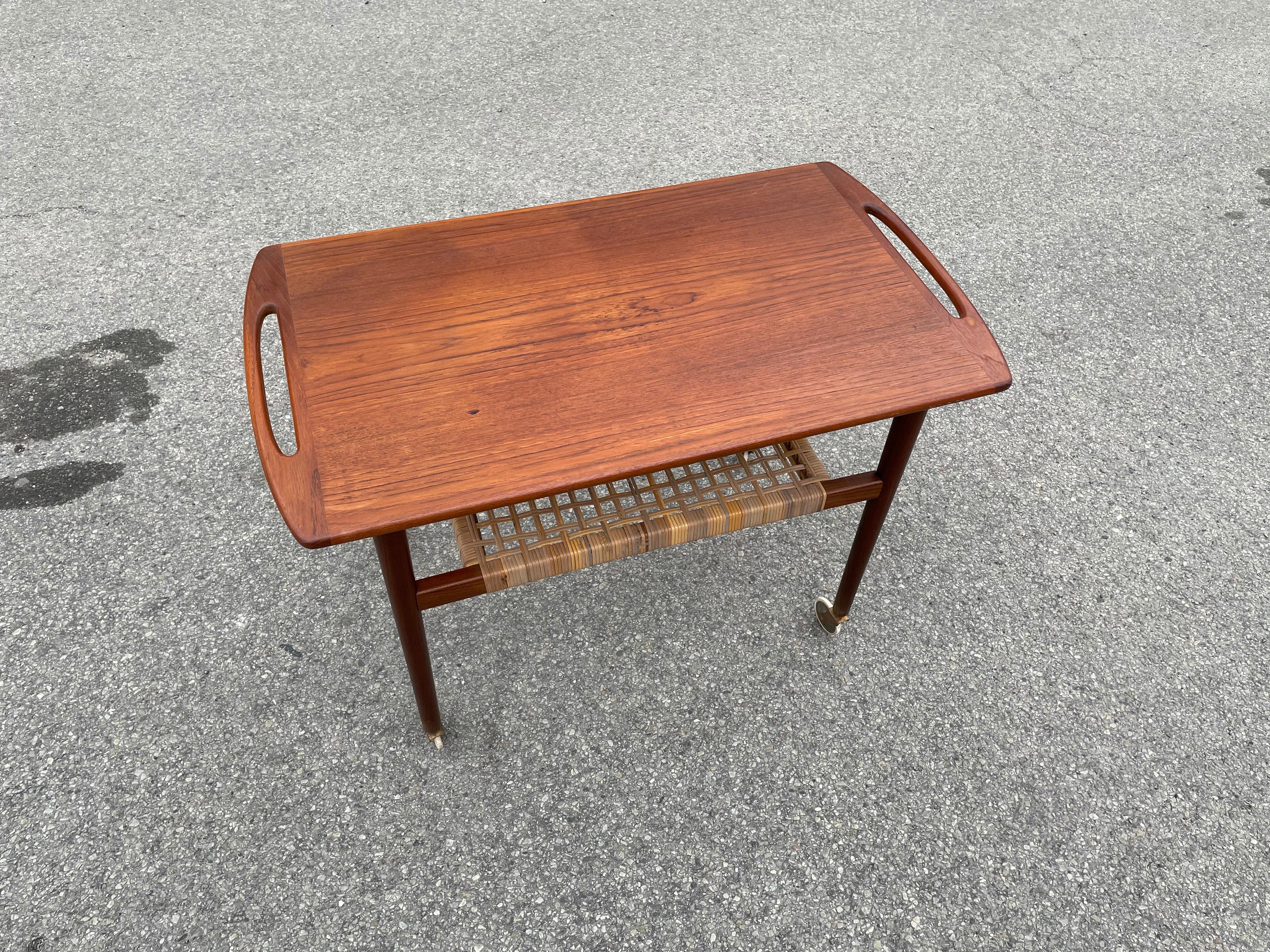 Vintage Danish teak serving trolley in teak and cane. Very slim and elegant design. Many uses as for an example a serving trolley, bar cart, side table or end table.
Good vintage condition, no structural issues.
